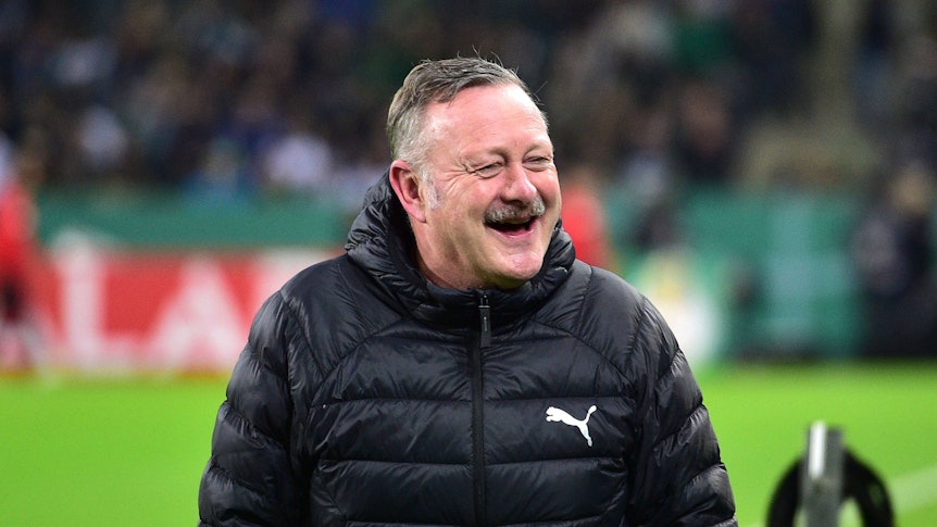 Roland Virkus lacht am Spielfeldrand im Borussia-Park.