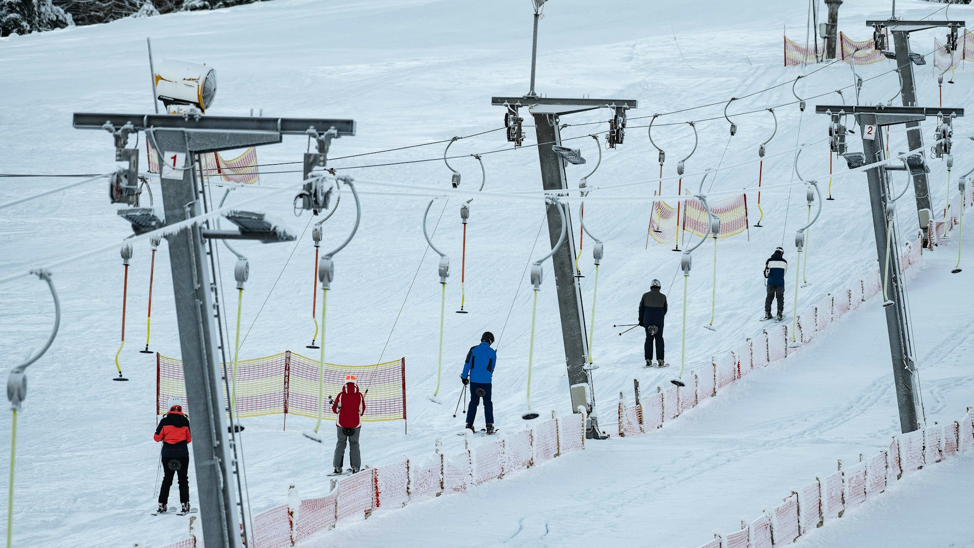 Wintersportler lassen sich am Ettelsberg im Skigebiet Willingen mit einem Schlepplift den Hang hochziehen.