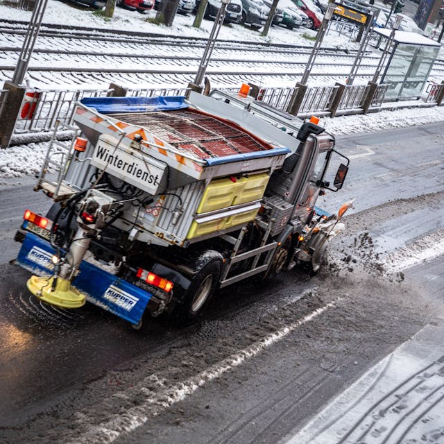 Ein mit einem Schneepflug ausgerüstet Fahrzeug der Abfallwirtschaftsbetriebe Köln (AWB) räumt 2021 mit seinem Räumschild Schnee und streut Streusalz auf der Straße „Sülzgürtel“. Nach Schneefall liegt in der Stadt eine dünne Schneedecke. Der nasse und schwere Schnee sorgt für matschige Straßen. (Symbolbild)