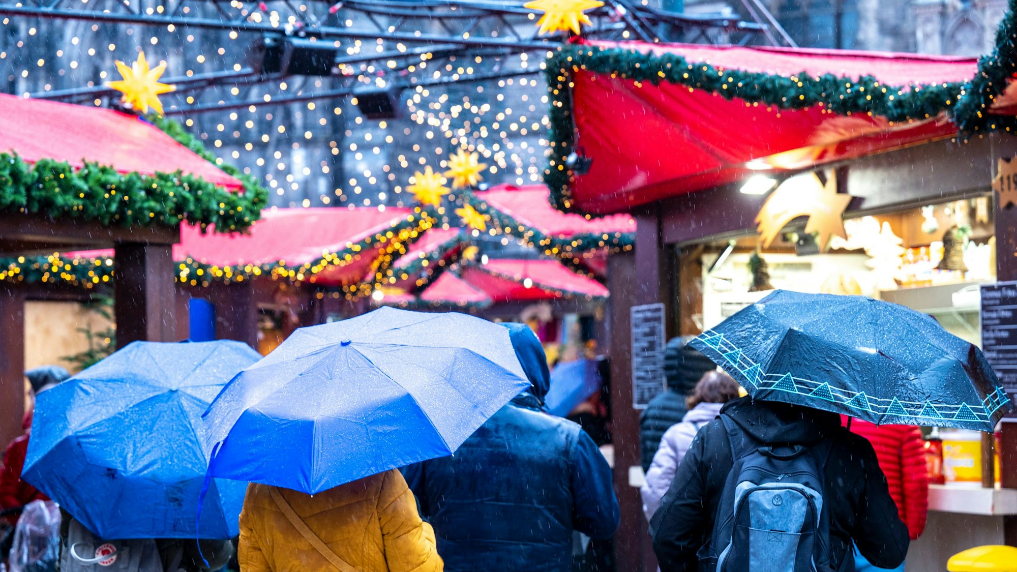 Mit Schirm über den Weihnachtsmarkt ist nicht besonders gemütlich. Unser Bild zeigt Besucher auf dem Weihnachtsmarkt auf dem Roncalli-Platz.