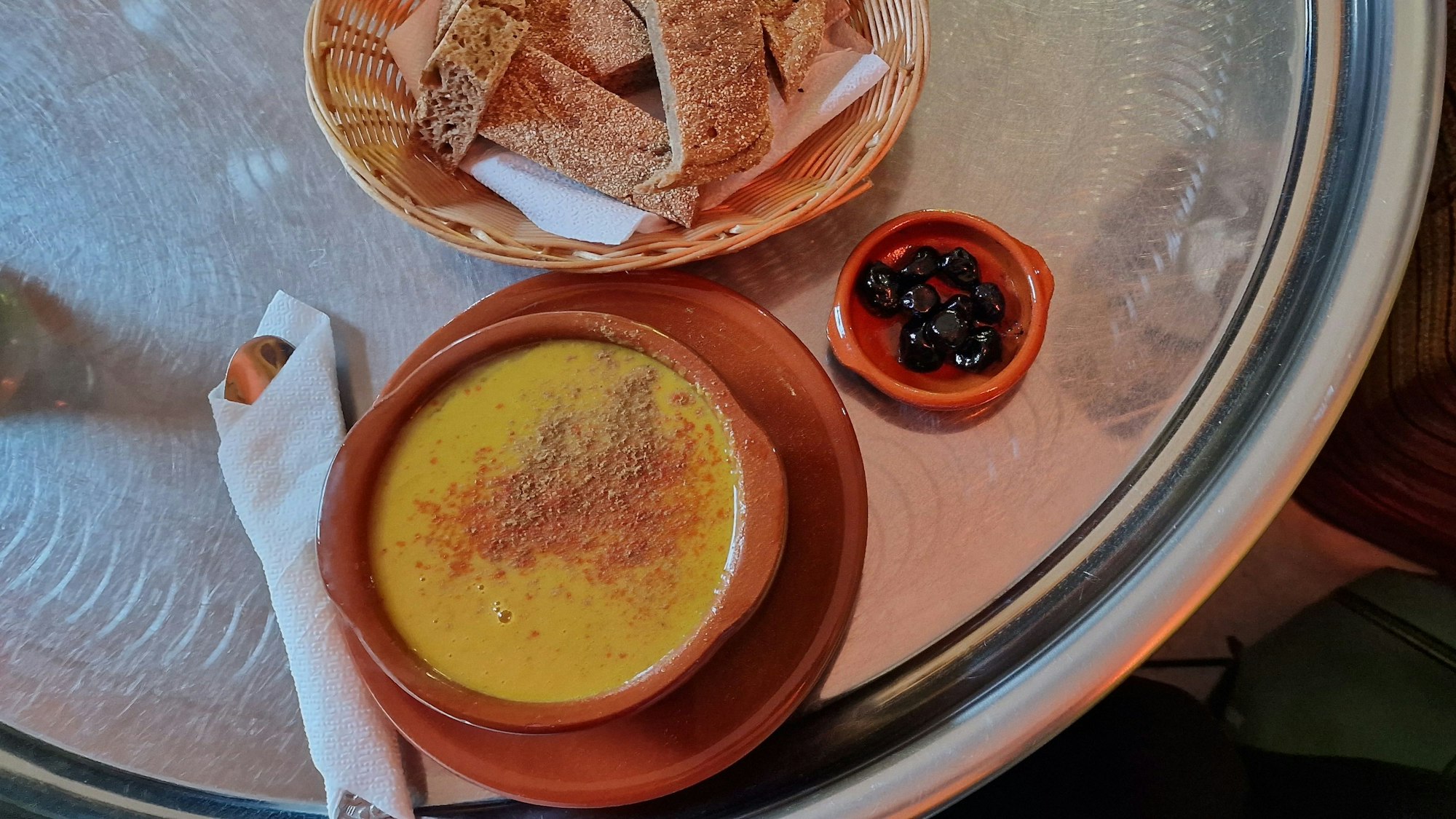 Bissara, marokkanische Spaltbohnensuppe, im Café Casablanca mit Oliven und Brot serviert.