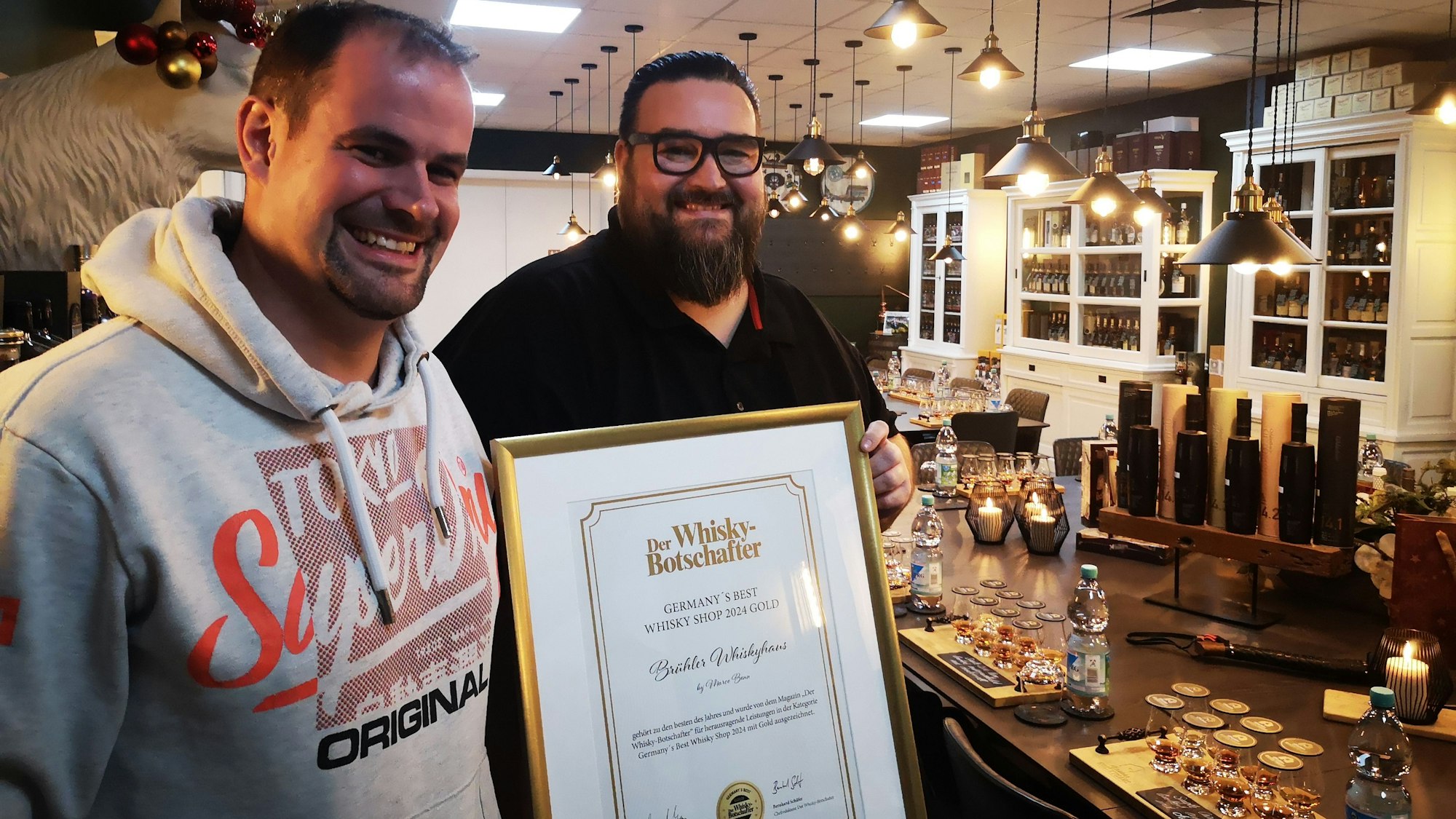 Patrick Swaton und Inhaber Marco Bonn (r.) mit der Urkunde für das Brühler Whiskyhaus als Bester Whiskyshop Deutschlands.