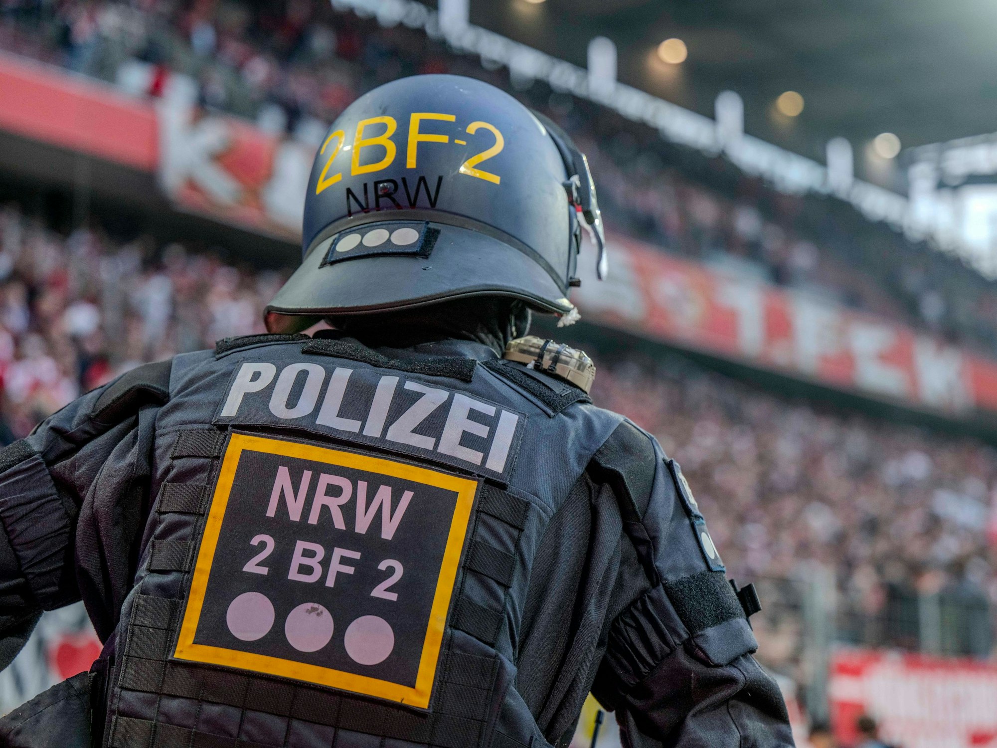 Ein Polizist im Rhein-Energie-Stadion beobachtet die Fans auf den Tribünen.