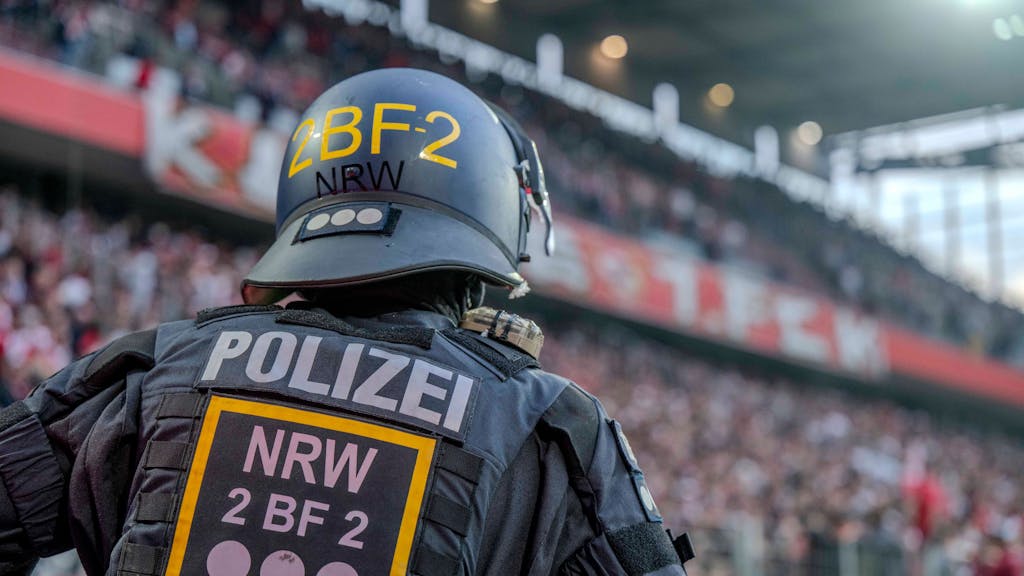 Ein Polizist im Rhein-Energie-Stadion beobachtet die Fans auf den Tribünen.&nbsp;