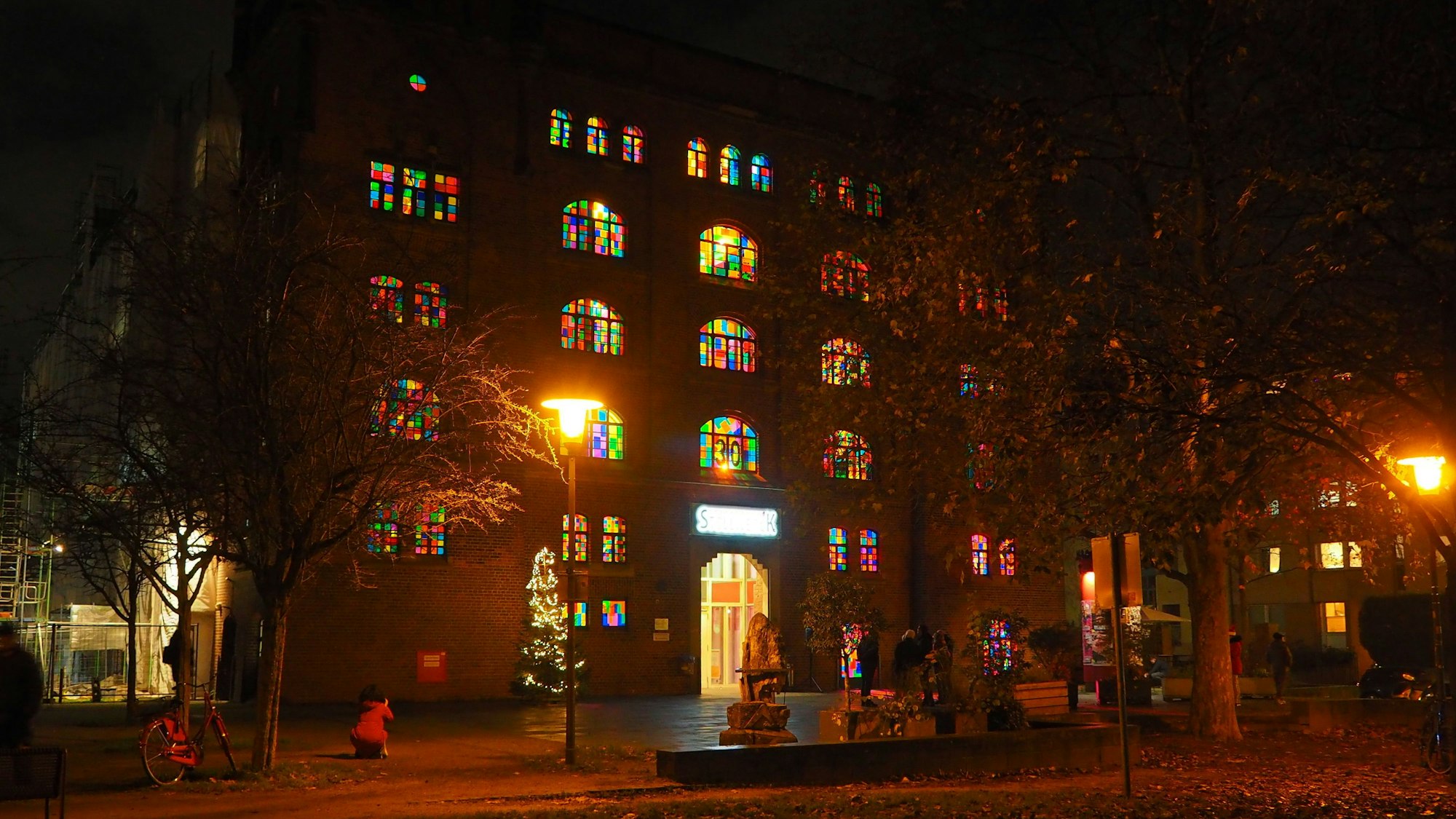 Bunt leuchten die Fenster an der Hauptfassade des Stollwerck im Advent.