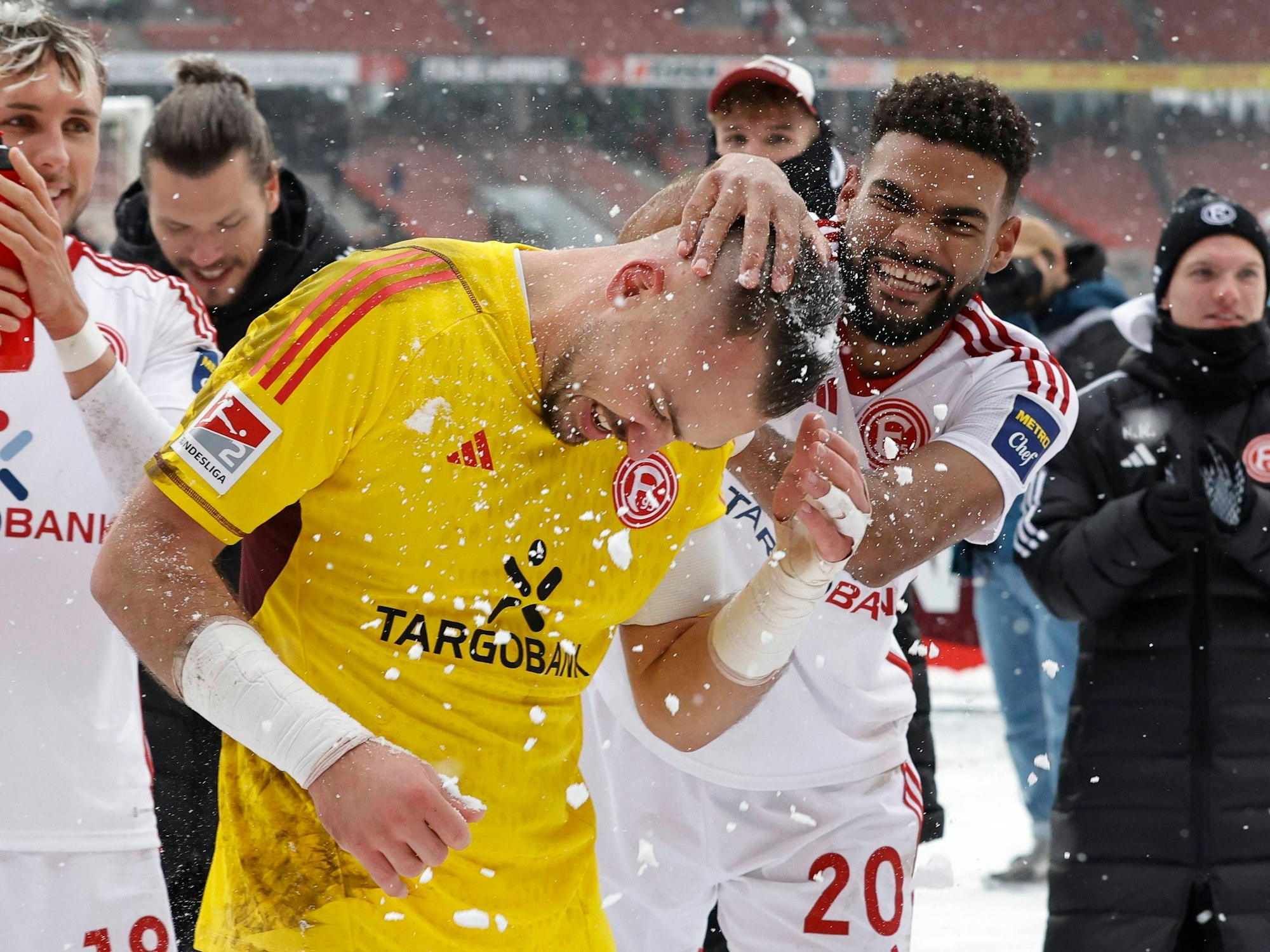 Fortuna Düsseldorfs Abwehrspieler Jamil Siebert drückt Keeper und Teamkollege Florian Kastenmeier eine Handvoll Schnee auf den Kopf.