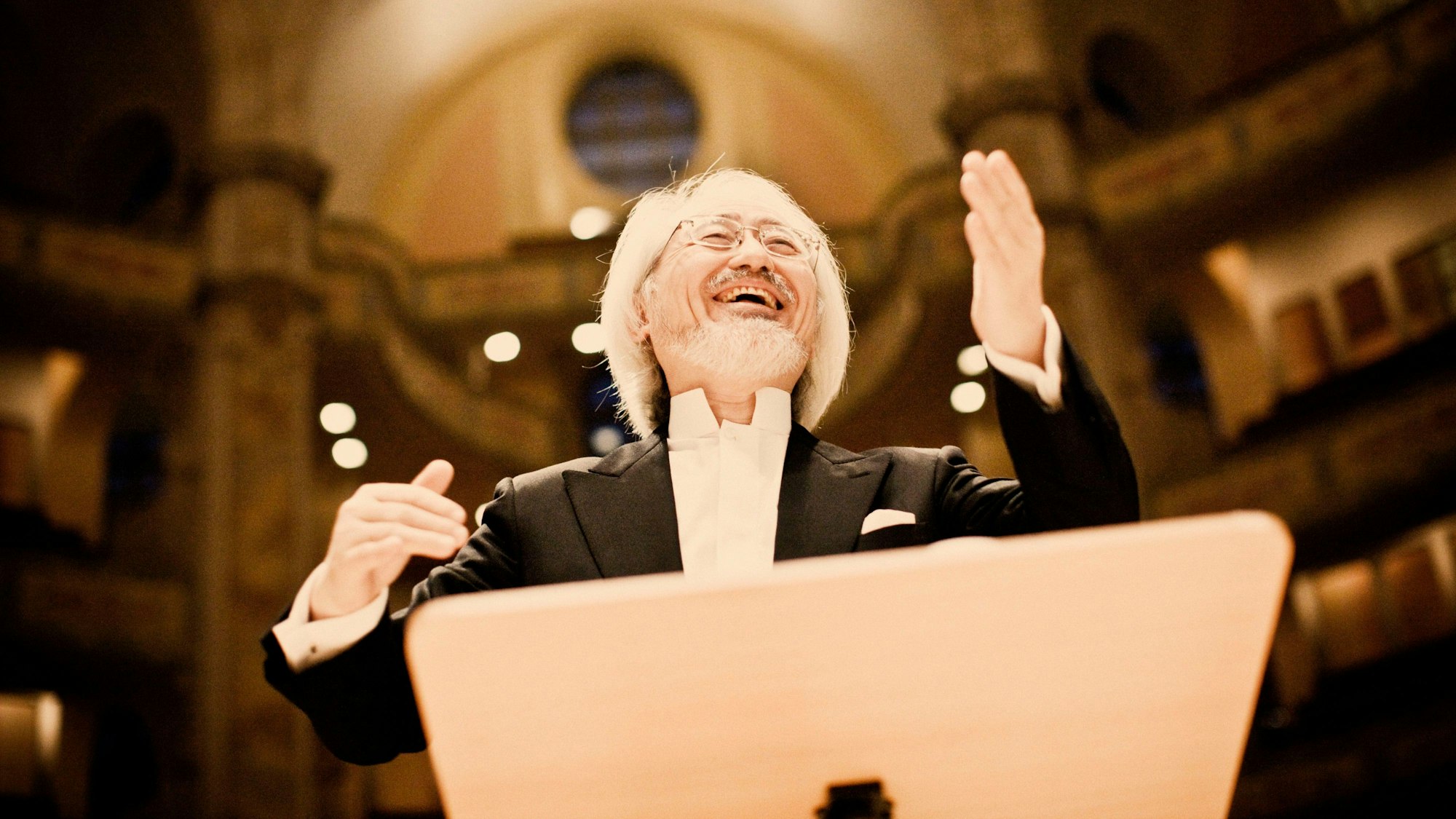 Masaaki Suzuki steht am Pult und dirigiert in der Frauenkirche Dresden.