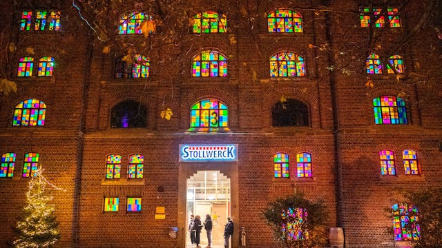 Front des Kölner Stollwercks mit bunt beleuchteten Fenstern