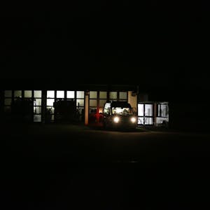 Ein Dieselgenerator spendet spärliches Licht im Feuerwehrhaus in Ruppichteroth, wo die Einsatzkräfte die Lage am Samstagabend genau im Blick haben. In mehreren Ortsteilen war stundenlang der Strom ausgefallen.