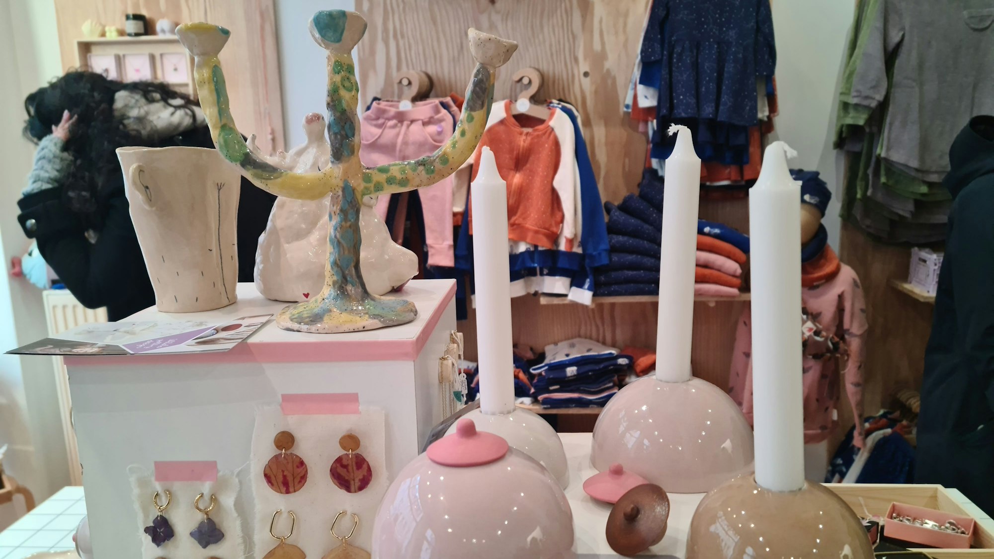 Schmuck, busenförmige Kerzenleuchter und Kindersachen sind in einem Ladenlokal ausgestellt.