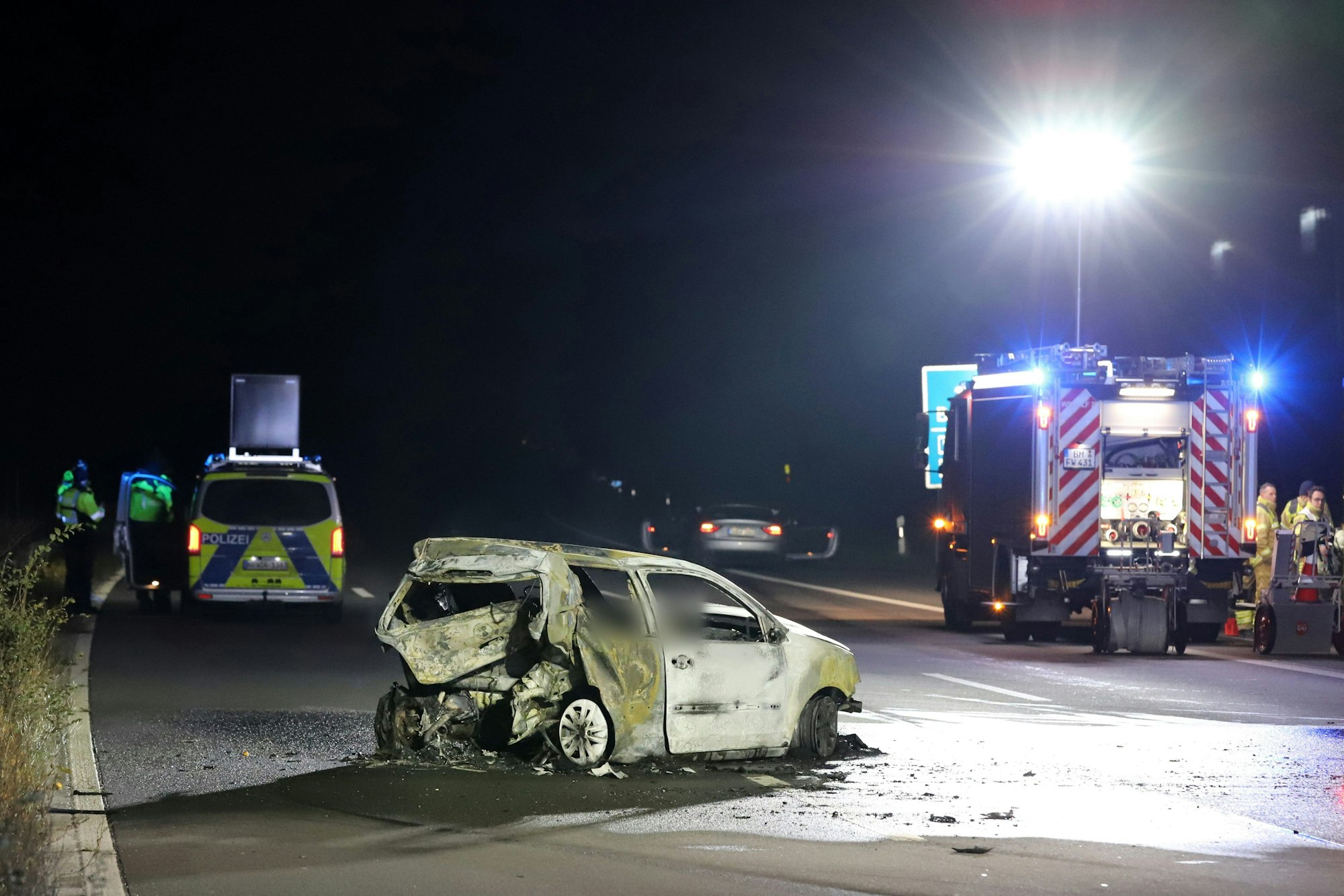 Ein ausgebranntes Auto steht in der Nacht zum 2. Dezember 2023 auf der Autobahn 555 zwischen Köln und Bonn.