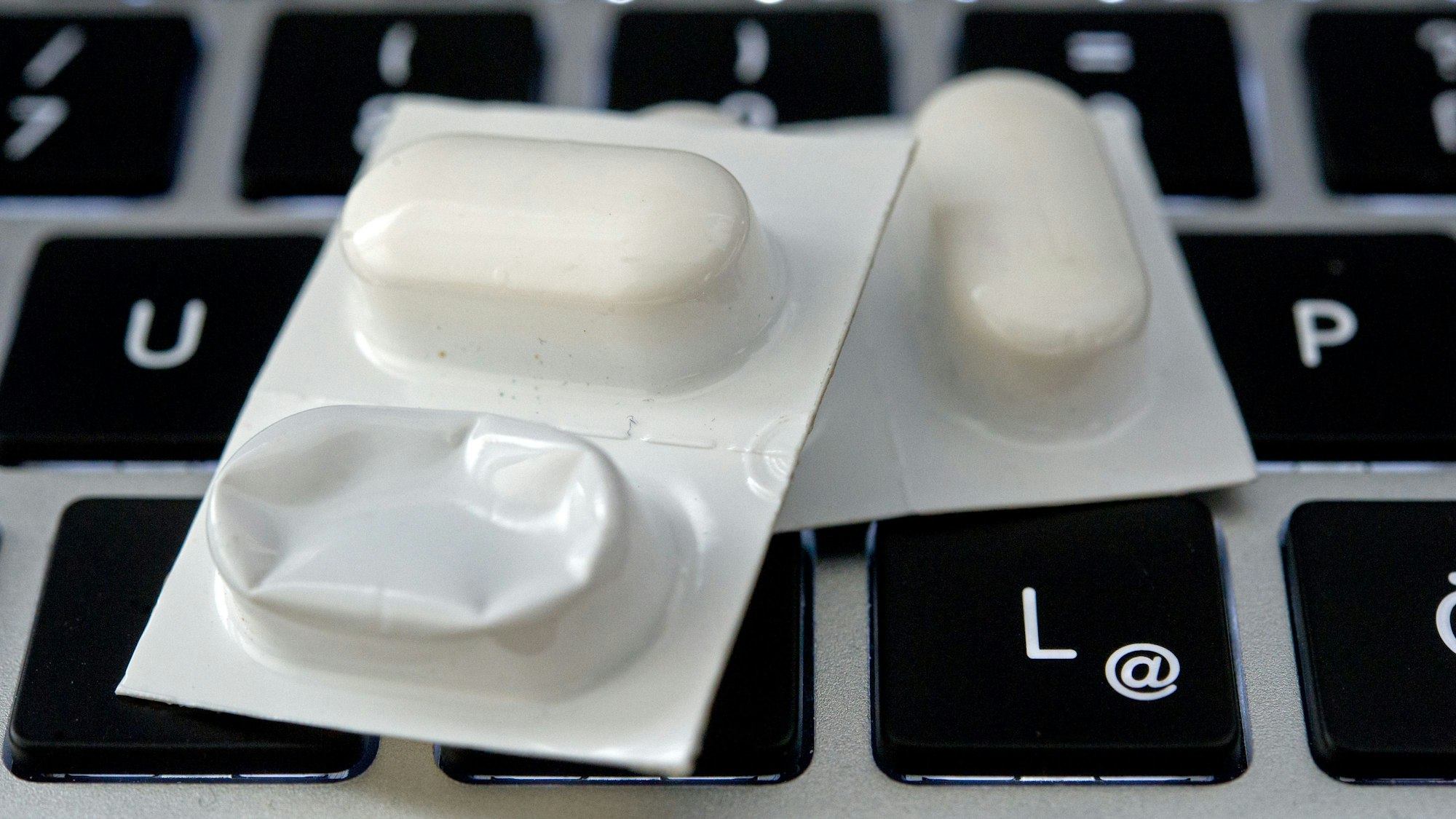 Blister mit Tabletten liegen auf einer Tastatur