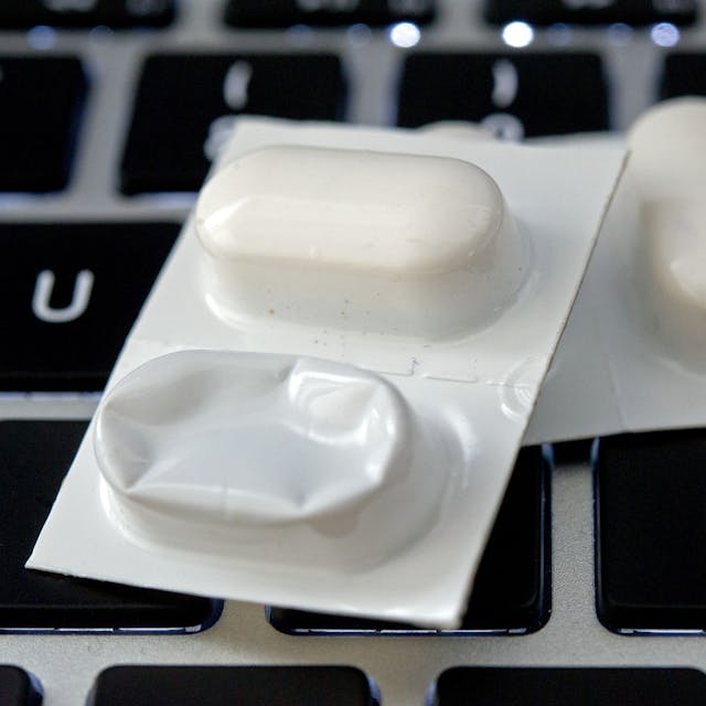 Blister mit Tabletten liegen auf einer Tastatur