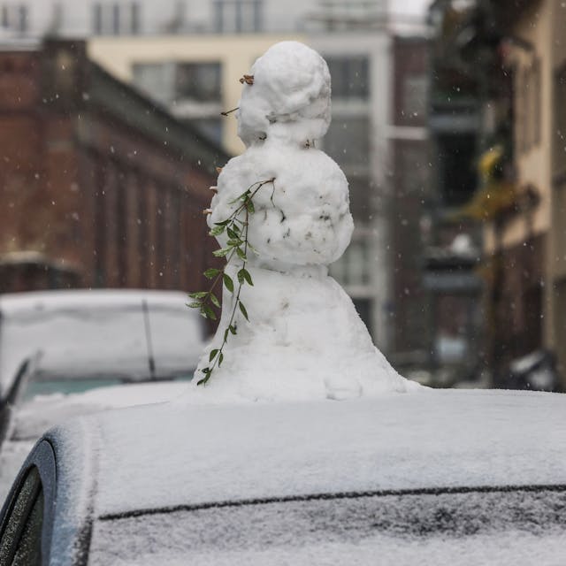 Ein Schneemann steht in Köln auf einem Autodach.&nbsp;