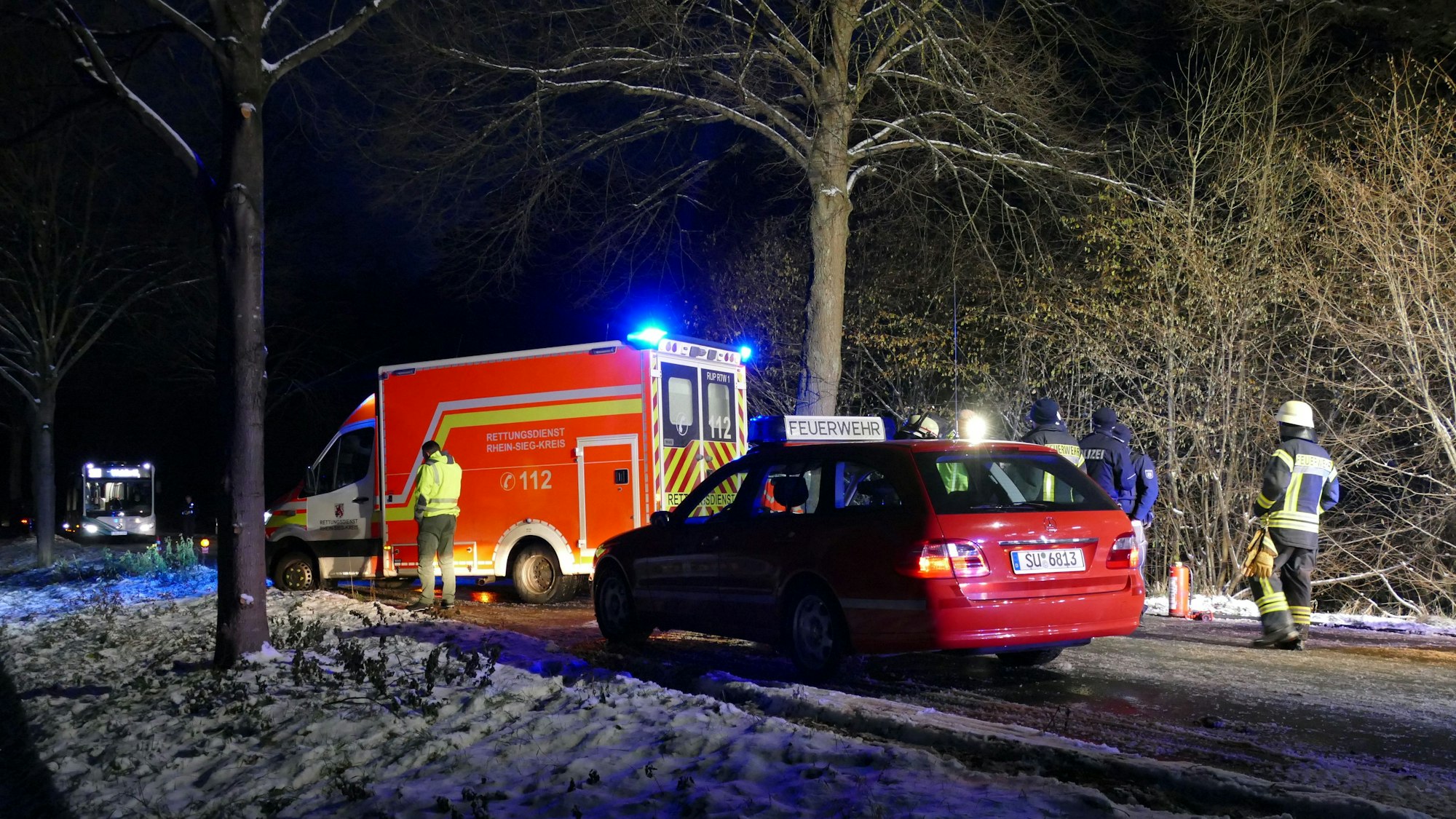 Ein Rettungswagen mit Blaulicht und ein Auto der Feuerwehr. Im Vordergrund Schnee.