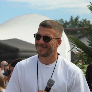 Mitorganisator Lukas Podolski lächelt 2023 auf dem „Glücksgefühle“-Festival am Hockenheimring. (Archivbild)