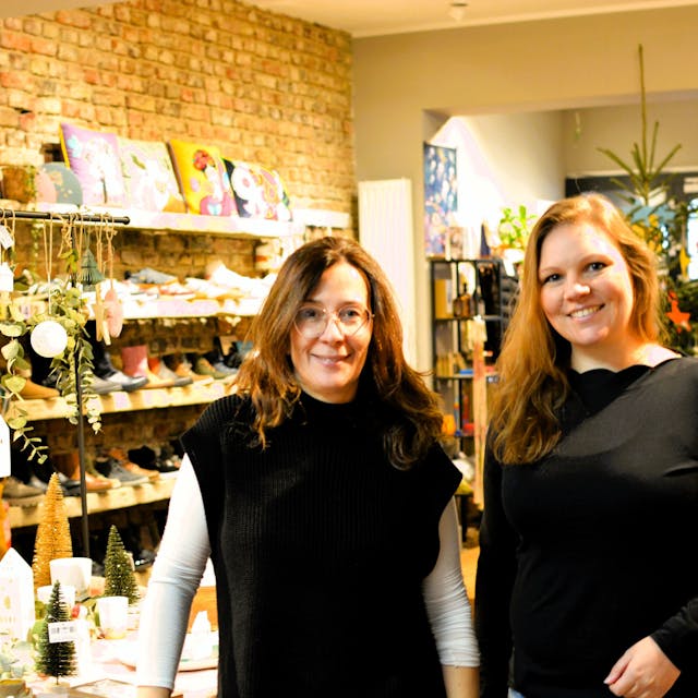 Heike Sommnitz und Lisa Schlömer stehen in einem Laden mit weihnachtlichen Deko-Artikeln und Schuhen.