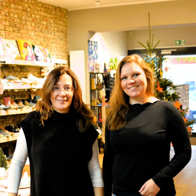Heike Sommnitz und Lisa Schlömer stehen in einem Laden mit weihnachtlichen Deko-Artikeln und Schuhen.