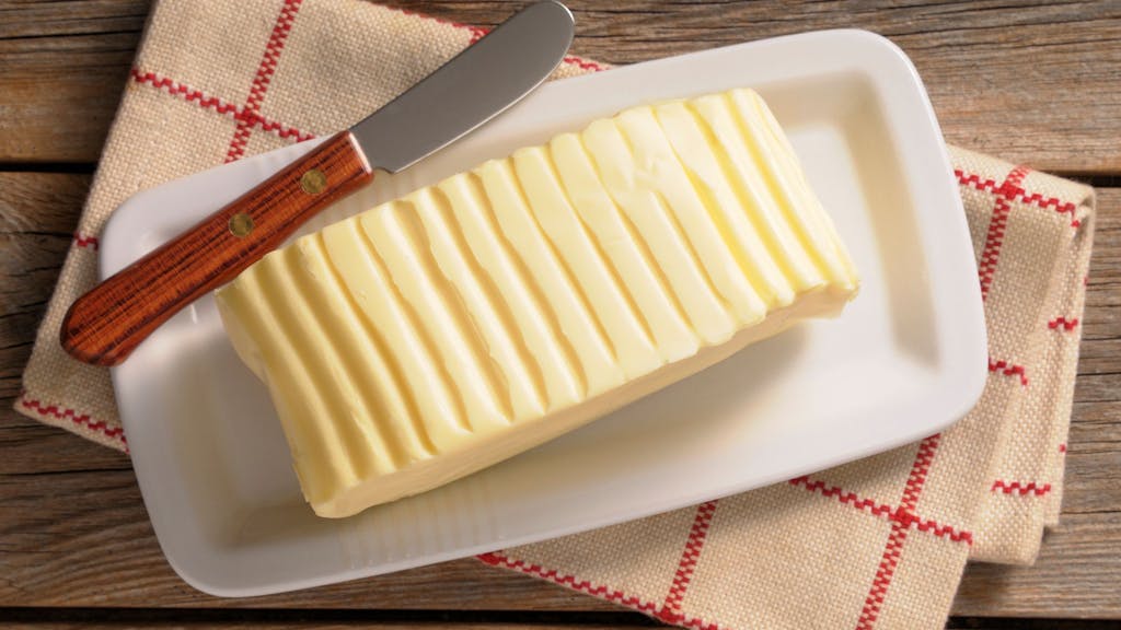 Auf dem Foto sieht man ein großes Stück Butter auf einem Teller liegen.