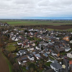 Das Bild zeigt den Ort Frauenberg aus der Luft fotografiert. Am Horizont sind Windräder zu erahnen.