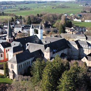 Das Luftbild zeigt das Gebäudeensemble des Klosters in Steinfeld. Im linken Bereich ist die Basilika mit ihren Türmen zu sehen.