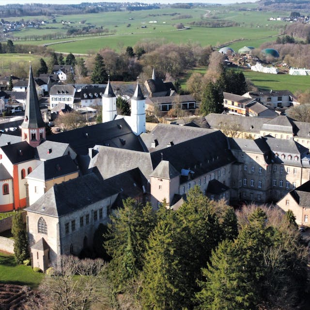 Das Luftbild zeigt das Gebäudeensemble des Klosters in Steinfeld. Im linken Bereich ist die Basilika mit ihren Türmen zu sehen.