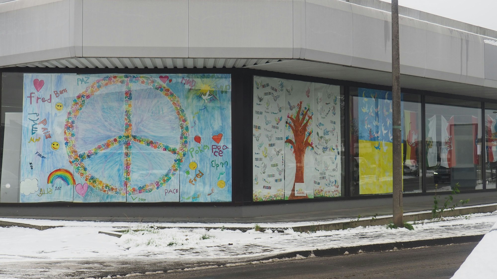 Ein großes Plakat mit dem Peace-Zeichen verdeckt ein Schaufenster.