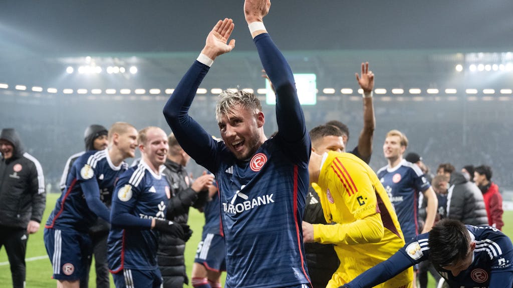Jona Niemiec jubelt mit der Mannschaft von Fortuna Düsseldorf vor der Fankurve nach dem Pokalspiel beim 1. FC Magdeburg.