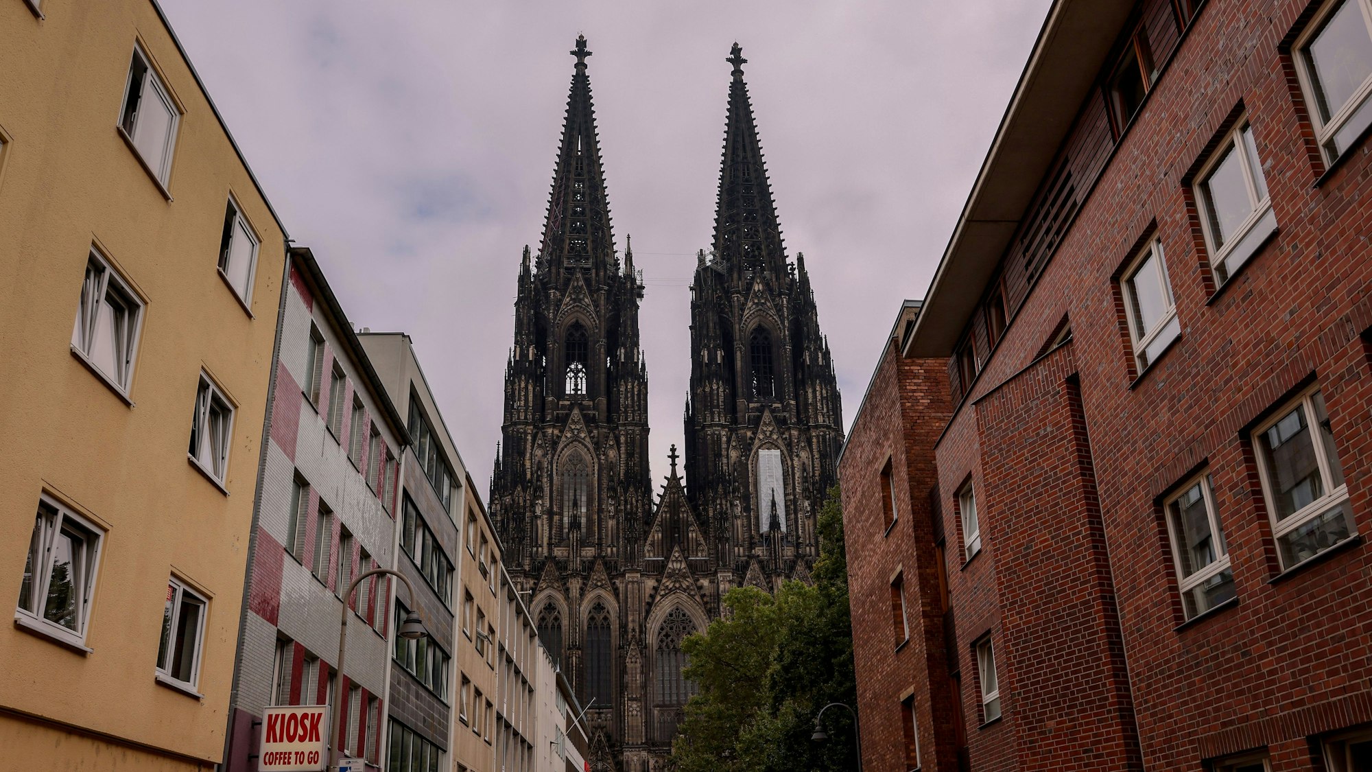 Zu sehen ist der Kölner Dom, eingerahmt von Hausfassaden.