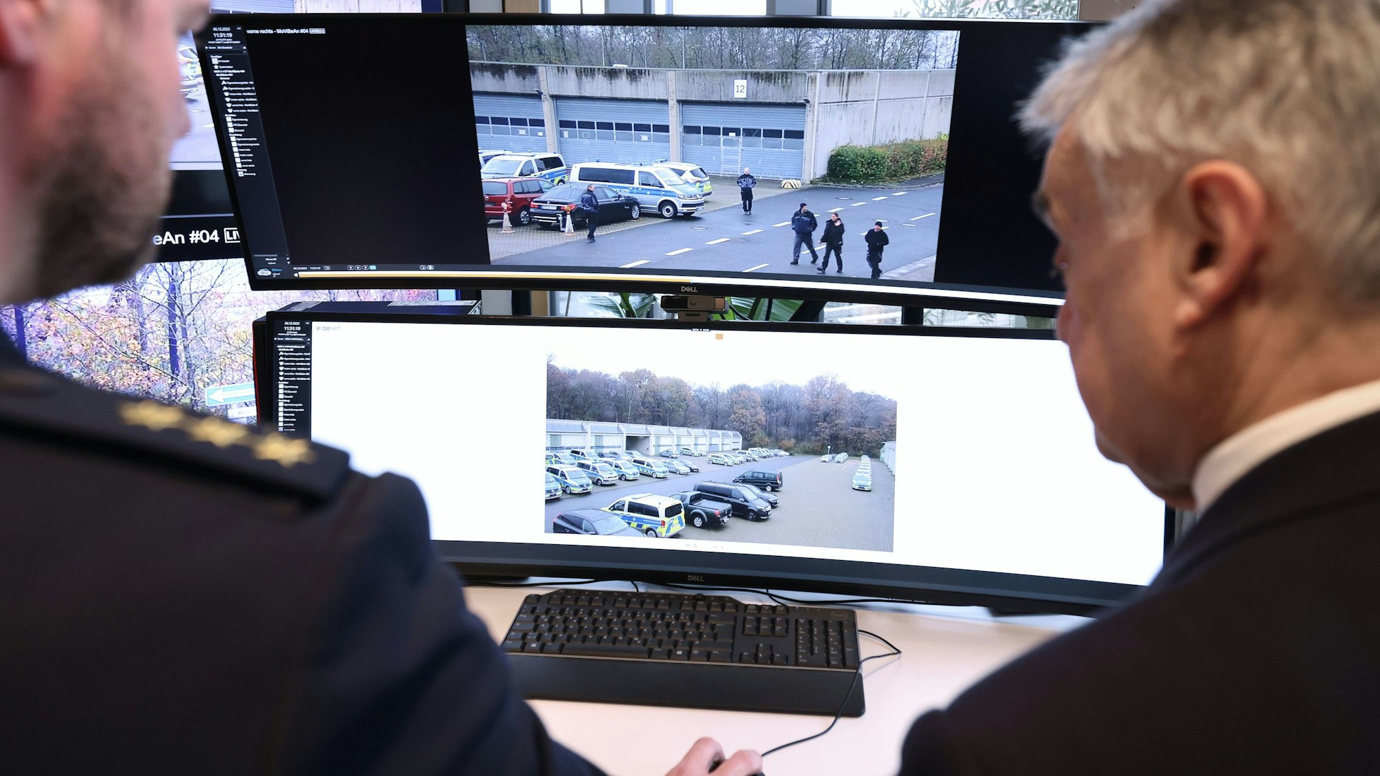 Christoph Meurers (l) erklärt Herbert Reul (CDU), Innenminister von NRW, die Aufnahmen der neuen mobilen Videobeobachtungsanlage der Polizei.