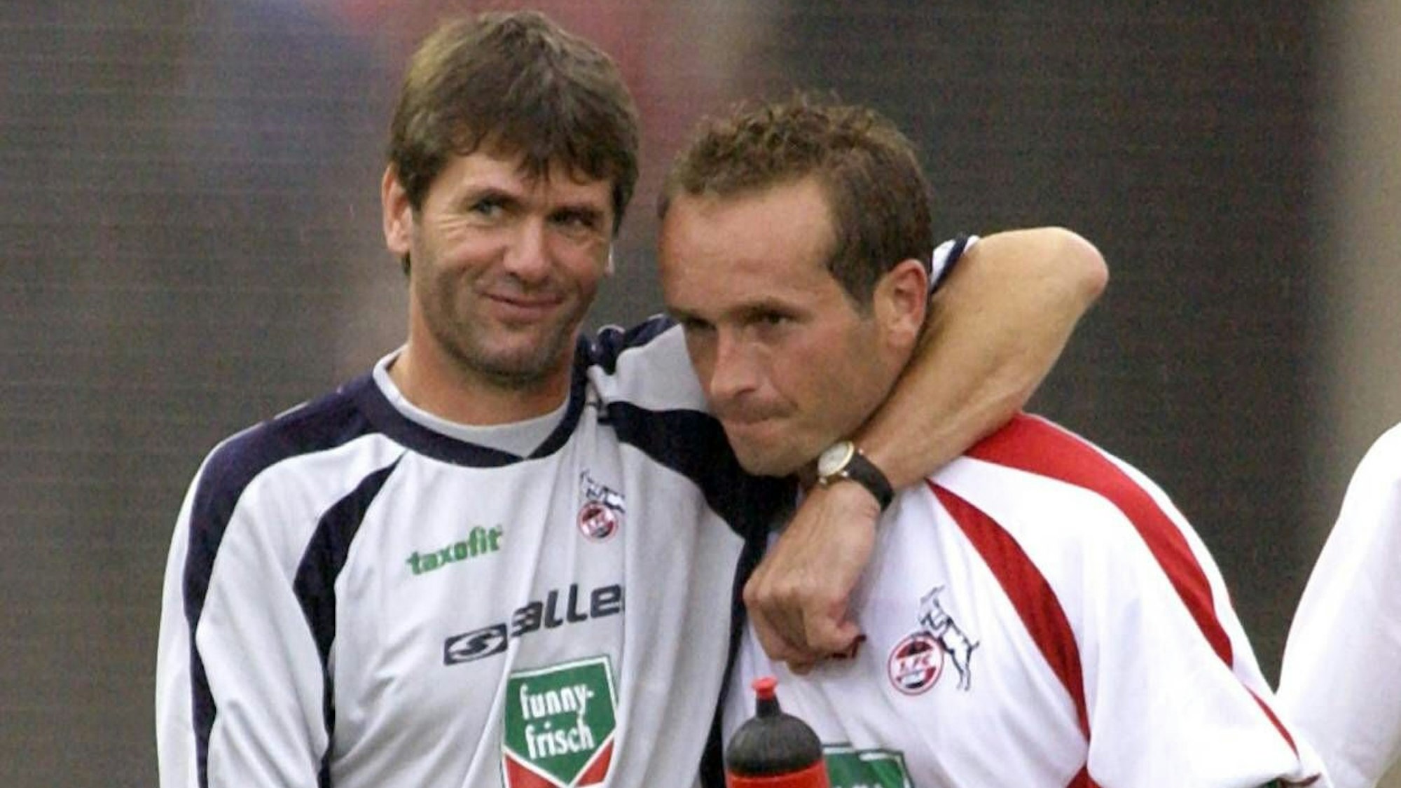 Friedhelm Funkel (li.) und Dirk Lottner umarmen sich nach einem Spiel des 1. FC Köln.