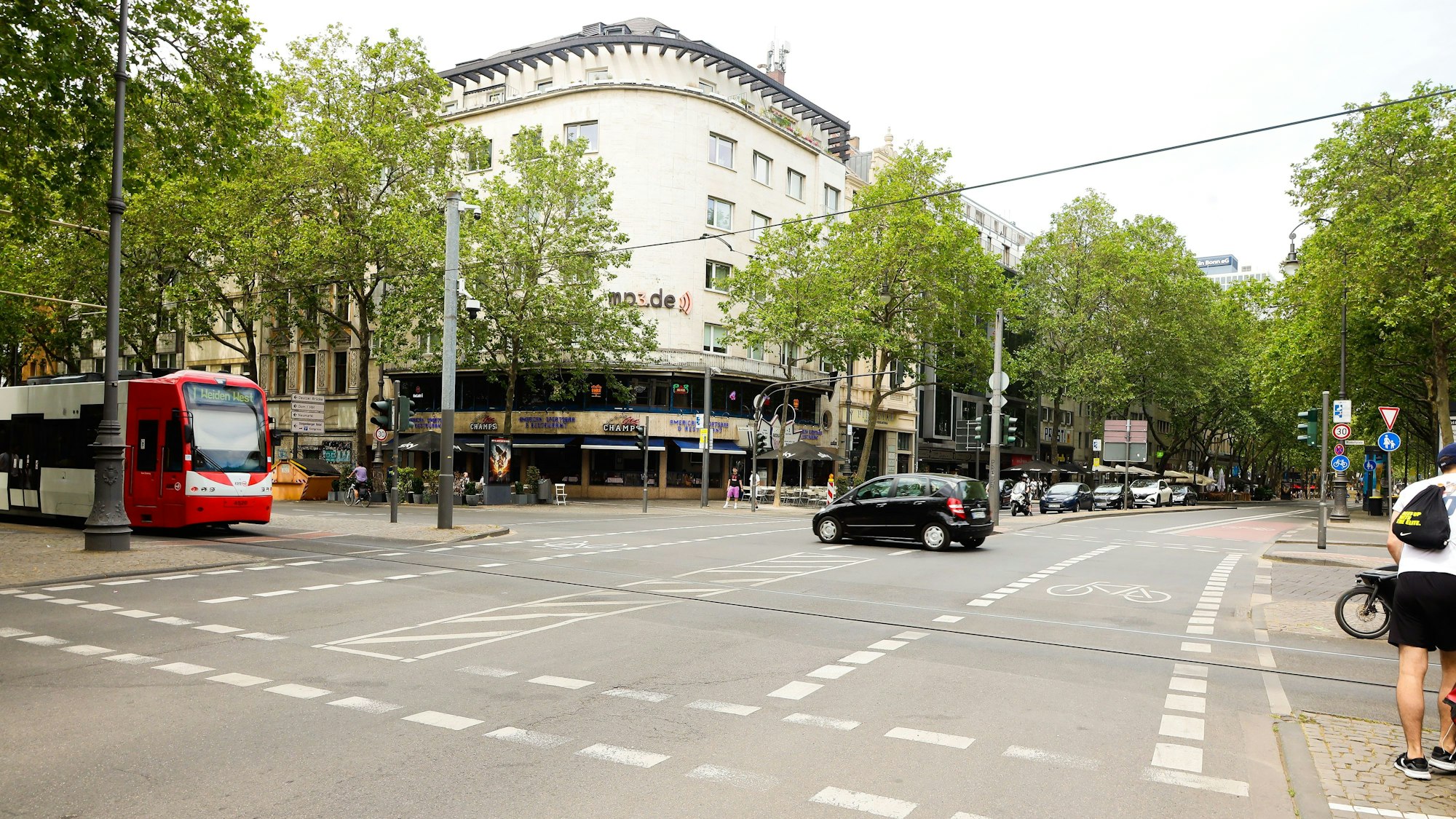 Autos und eine KVB-Bahn fahren am Kölner Rudolfplatz.
