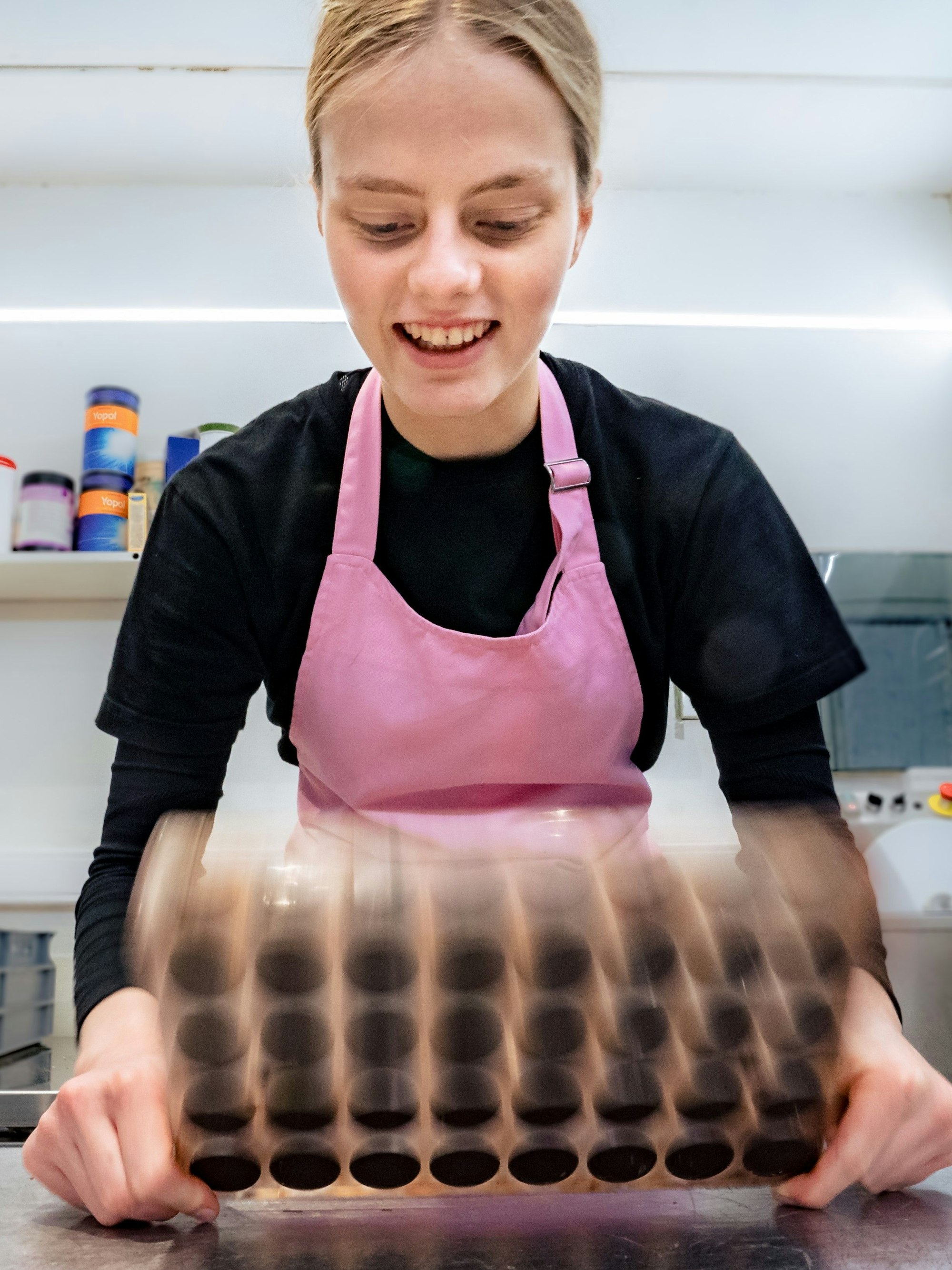 Pauline Decker bei der Arbeit, in den Formen wird die Schokoladenschale hart.