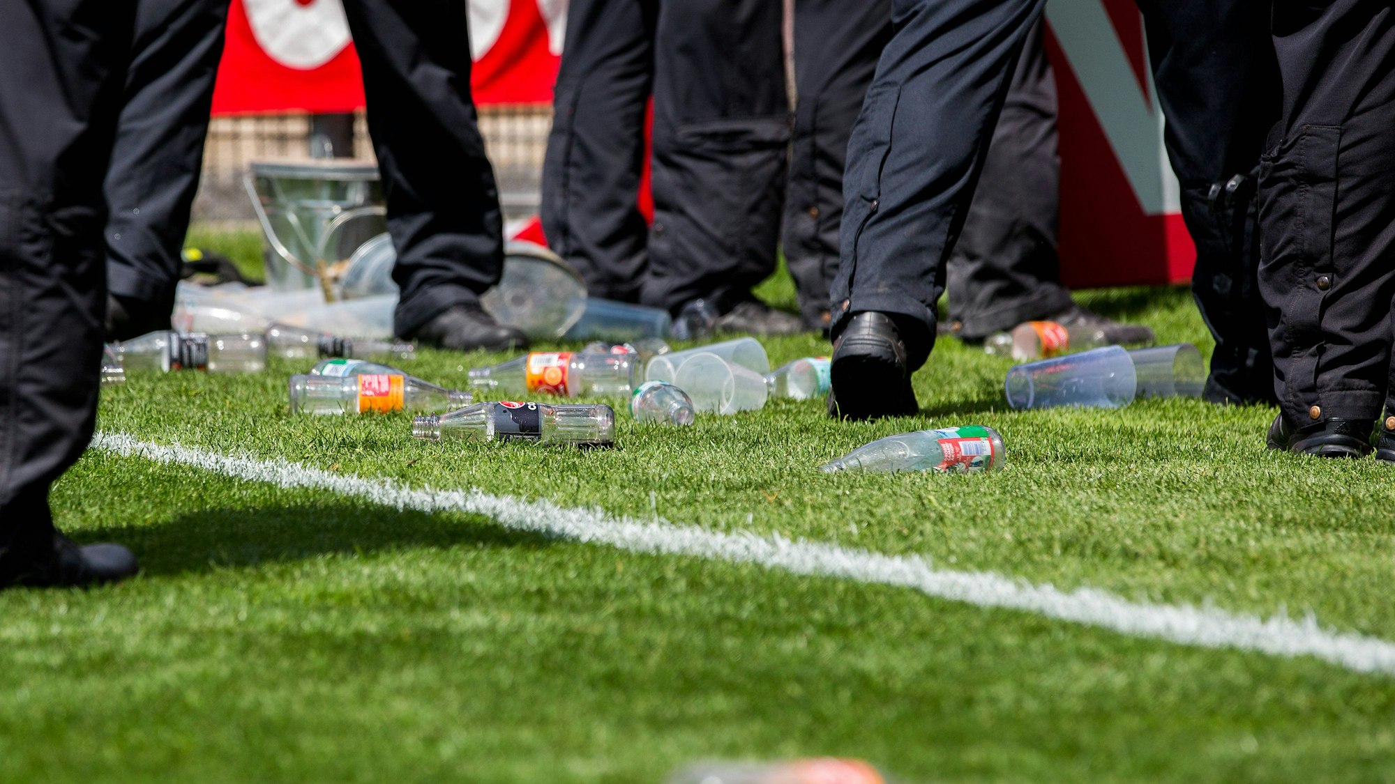 Das Symbolfoto zeigt geworfene Flaschen und Becher beim Heimspiel derSpielvereinigung Unterhaching am 11. Juni 2023 gegen Energie Cottbus.