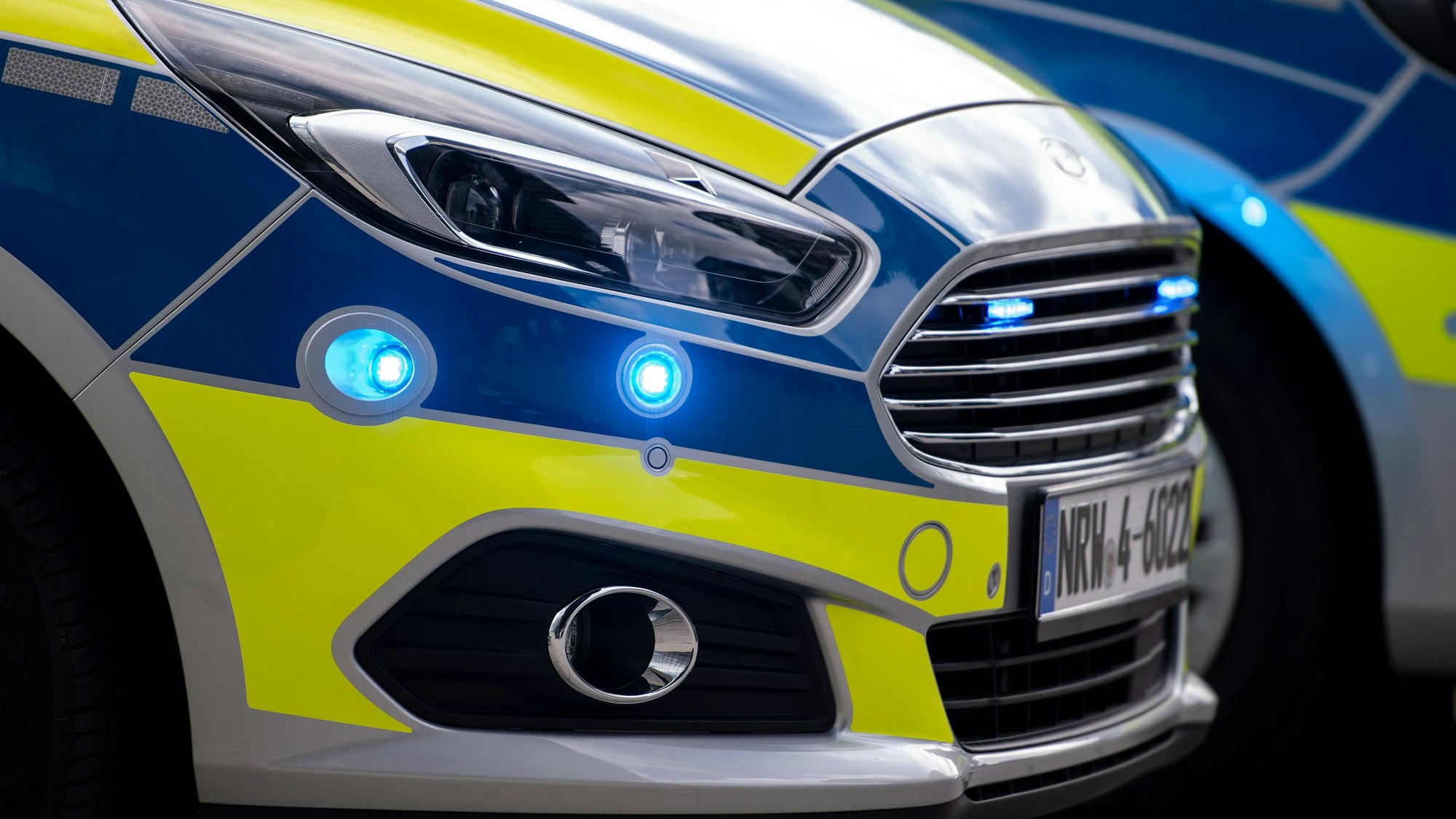 Blaulichter blinken an der Seite eines Polizeiwagens vom Typ Ford S-Max.