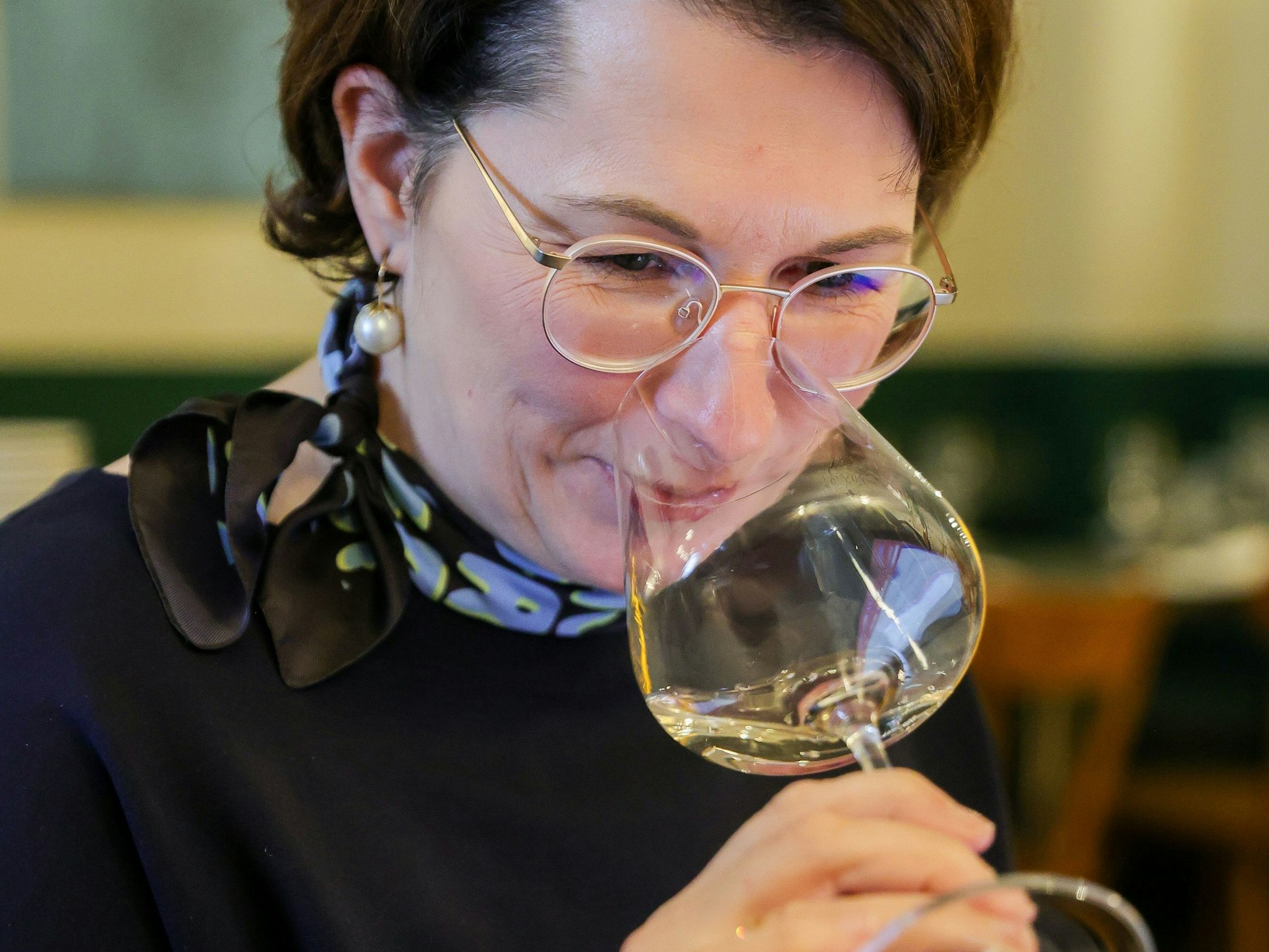 Sommelière und Master of Wine Romana Echensperger riecht an einem Glas.