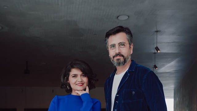 Pınar Karabulut und Rafael Sanchez blicken in die Kamera. Sie trägt einen blauen Pullover, er ein blaues Hemd.
