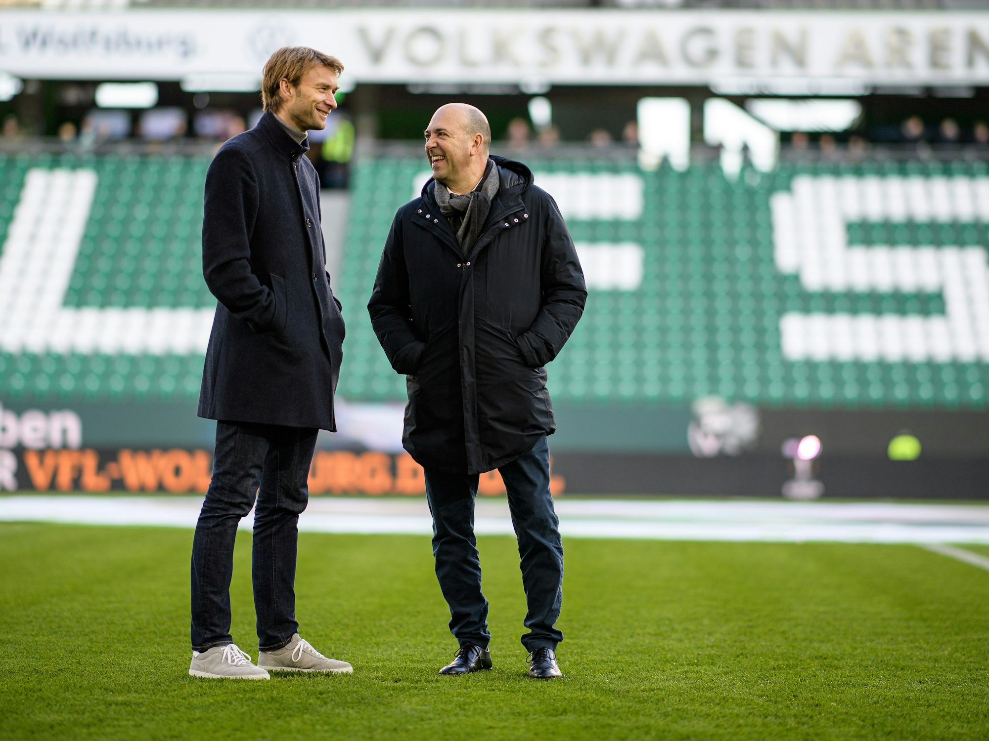 Simon Rolfes und Leverkusens Geschäftsführer Fernando Carro (r.) stehen auf dem Spielfeld beim VfL Wolfsburg.