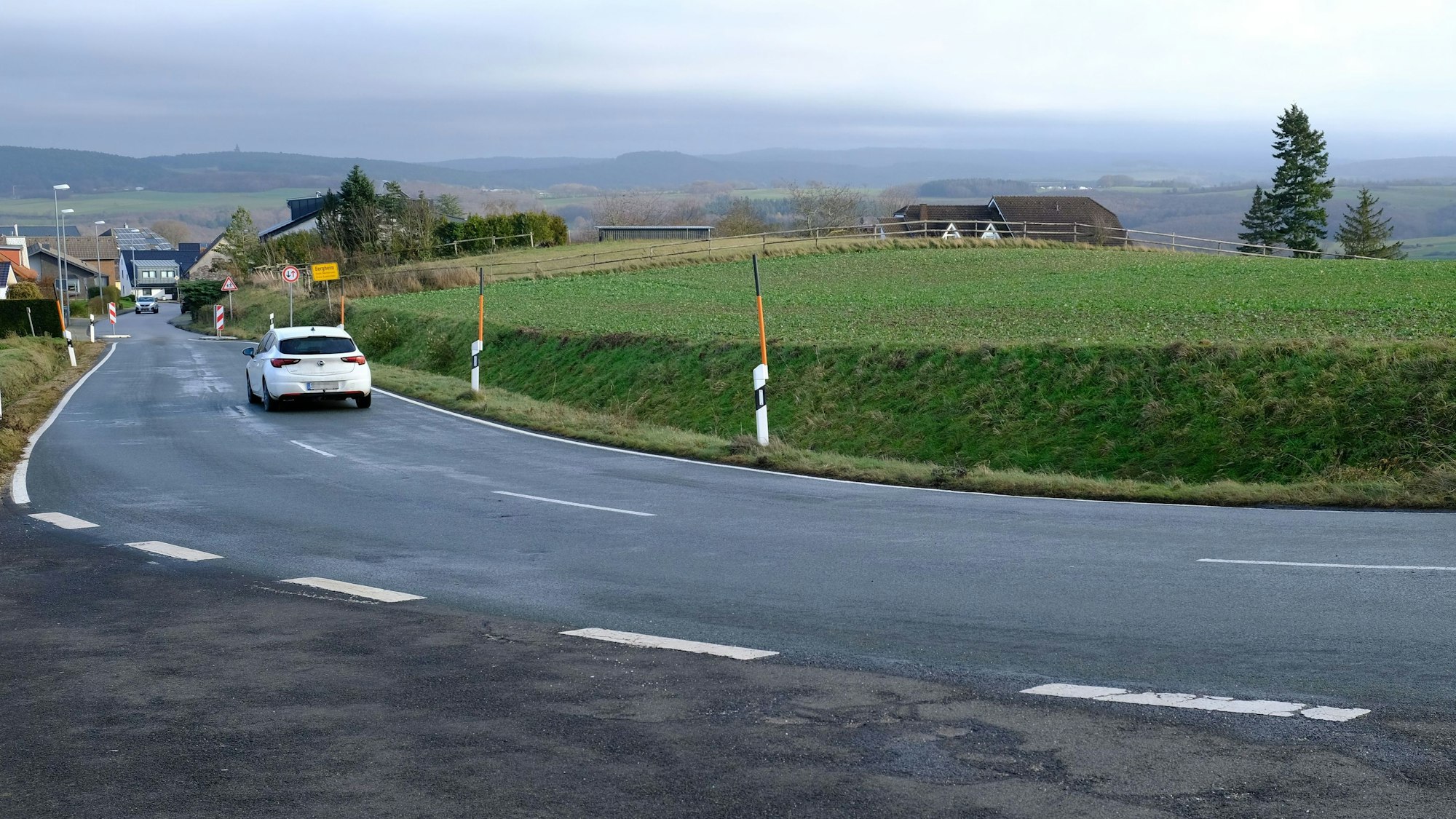 Hinter einer Straße, am Ortsrand von Mechernich-Bergheim, liegt eine Ackerfläche, die bald zum Baugebiet werden soll.