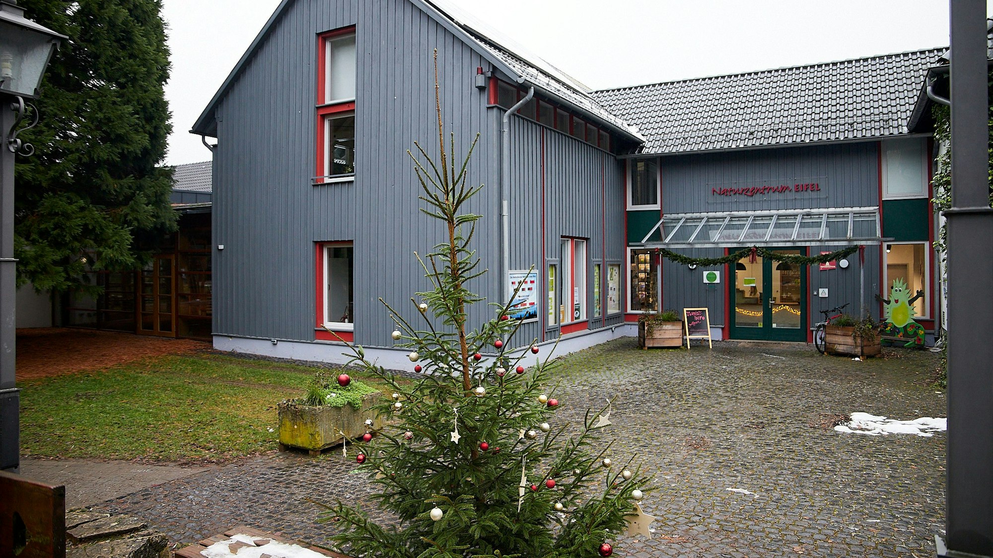 Das Naturzentrum in Nettersheim, vor dem ein Weihnachtsbaum steht, ist nach der Flut saniert worden und seit wenigen Wochen wieder geöffnet.
