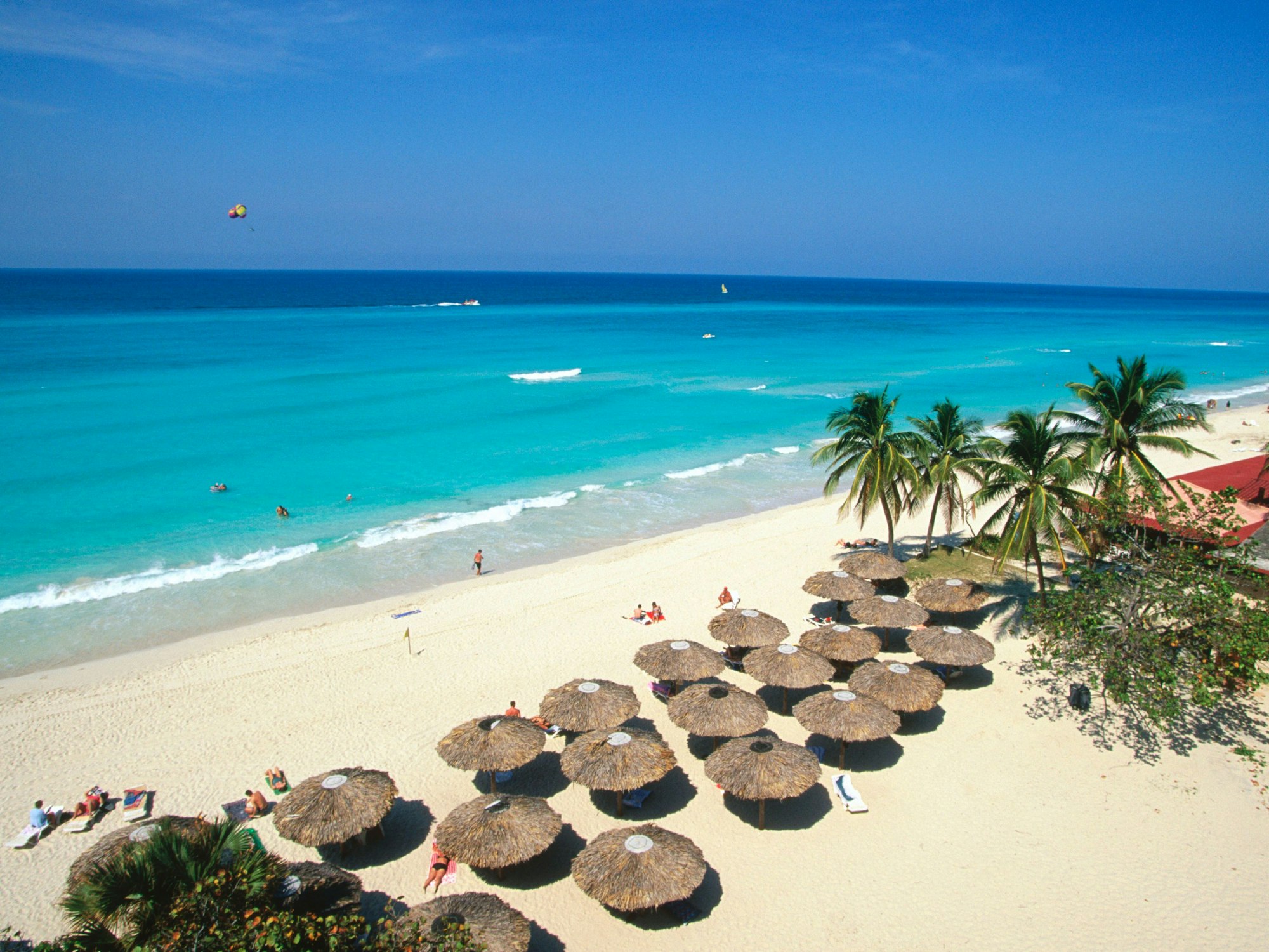 Schirme, Palmen und Badegäste am Varadero Beach auf Kuba, hier im Januar 2021.