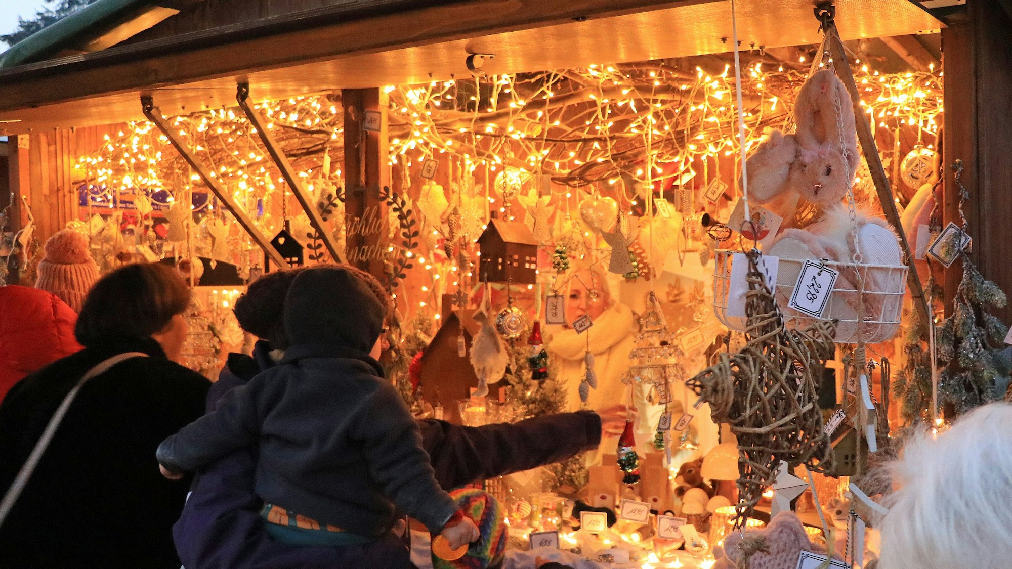 Auf dem Bild ist ein hell erleuchteter Stand auf dem Weihnachtsmarkt zu sehen.