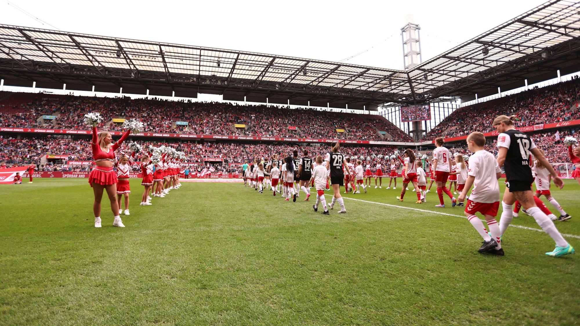 Im gut gefüllten Rhein-Energie-Stadion laufen die Spielerinnen des 1. FC Köln und von Eintracht Frankfurt im Rhein-Energie-Stadion ein.