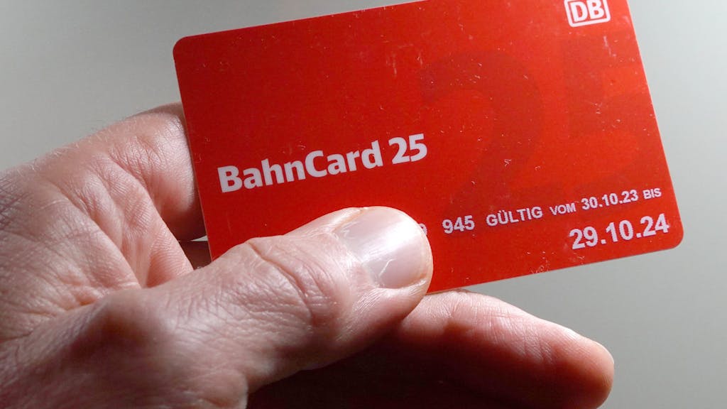 Ein Mann hält eine BahnCard 25 in der Hand.