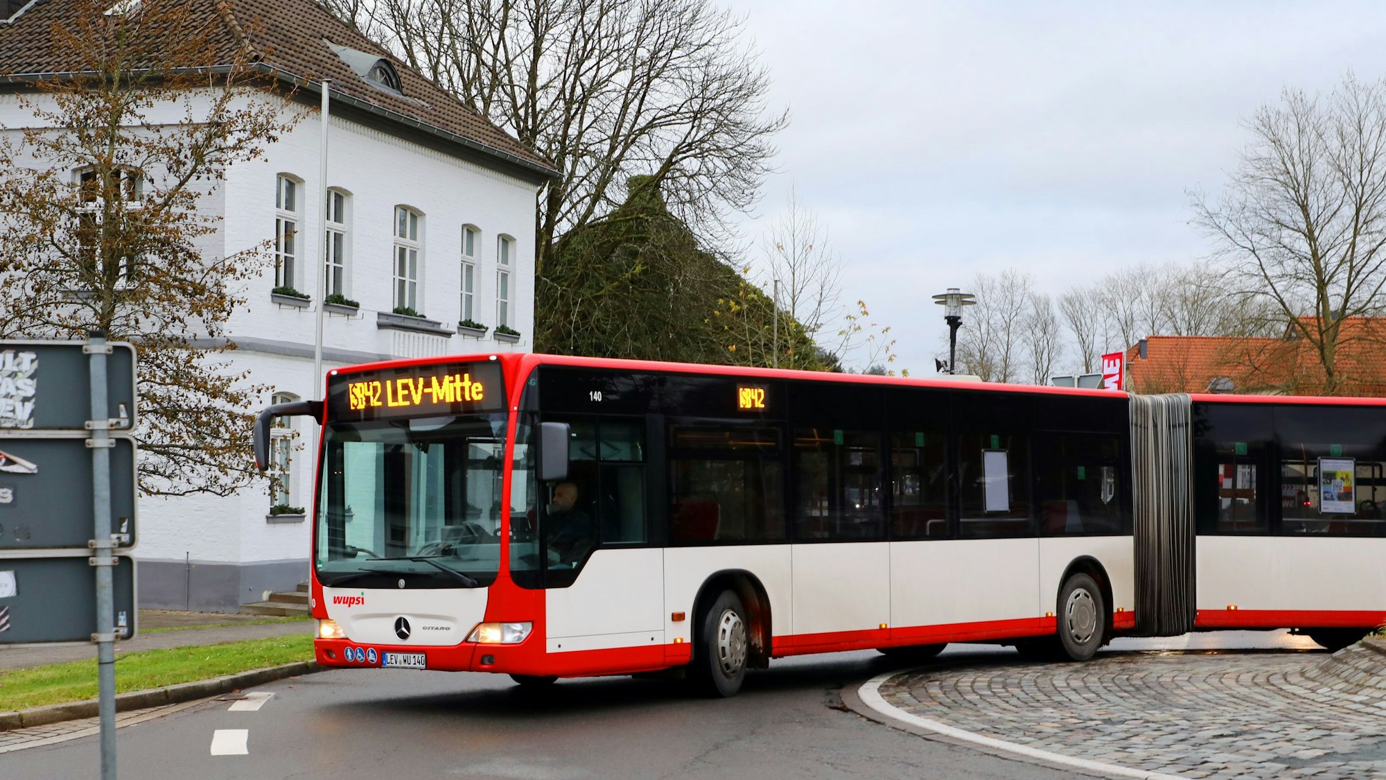 Ein Bus mit der Aufschrift SB 42 fährt durch den Kreisverkehr am Odenthaler Rathaus.