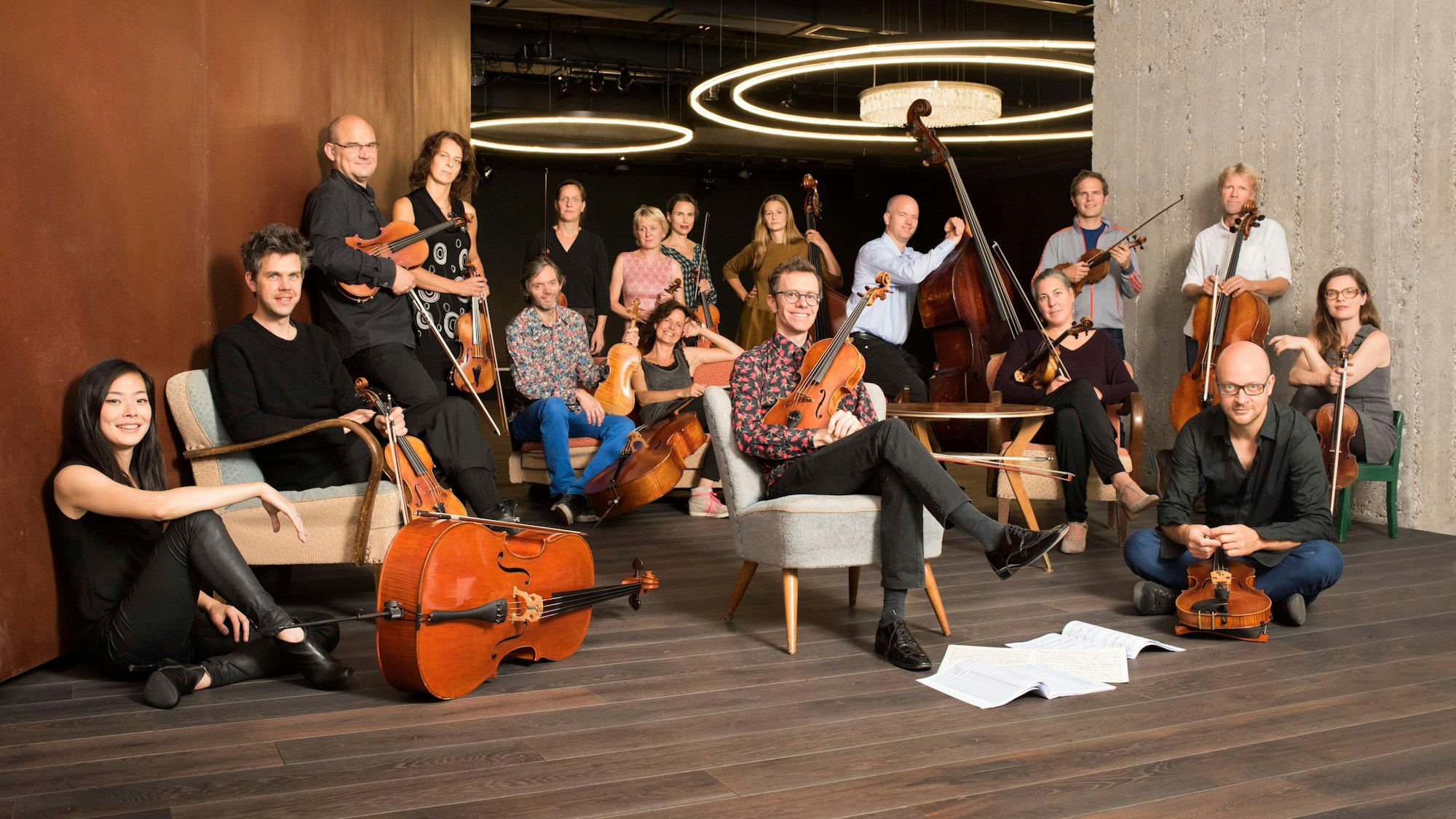Die Musiker des Ensembles Resonanz posieren sitzend und stehend mit ihren Instrumenten im Resonanzraum St. Pauli.