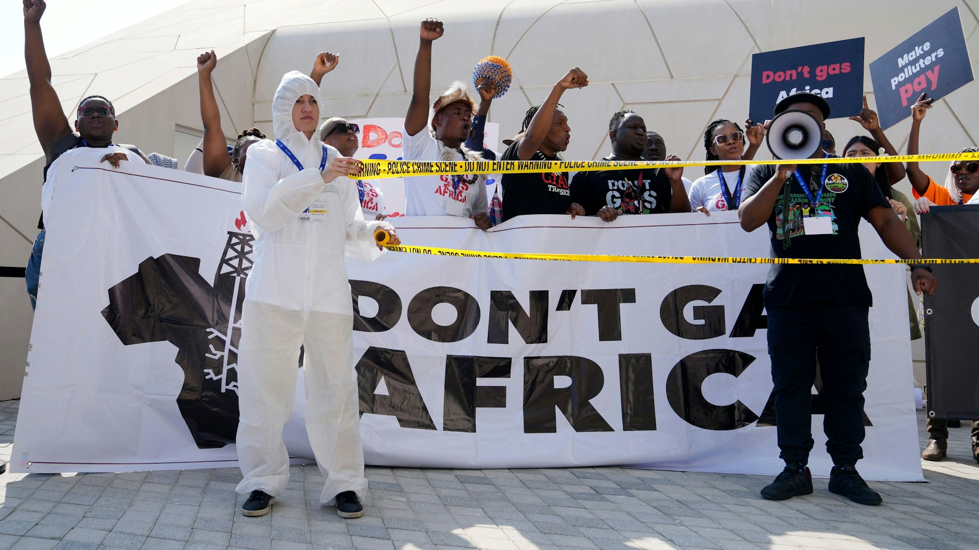 Aktivisten halten auf einer Demonstration während der Weltklimakonferenz Plakate und Transparente mit der Aufschrift „Don't gas Africa“ und „Make polluters pay“ in die Höhe.