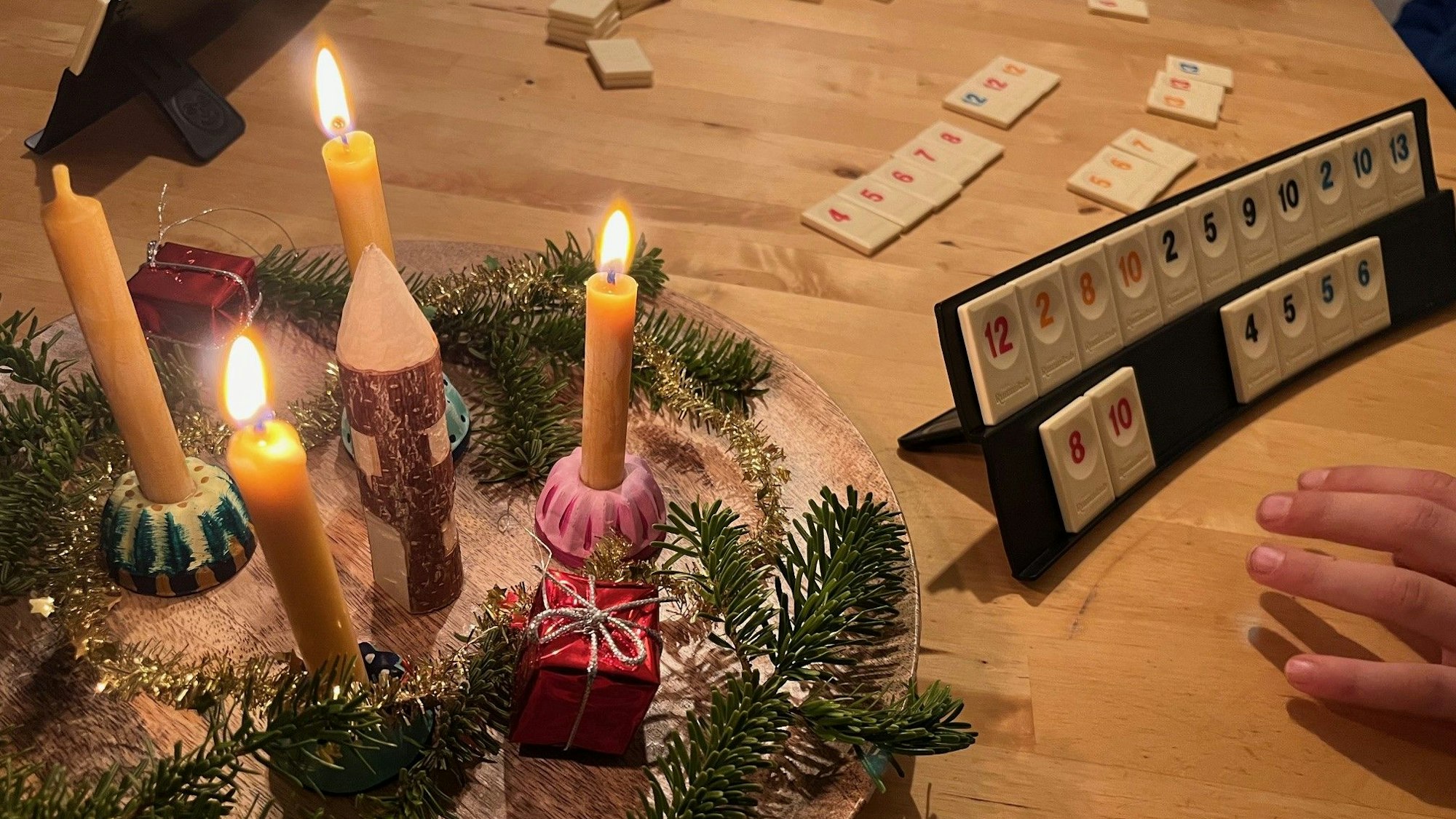 Spielszene Rummikub neben weihnachtlicher Deko