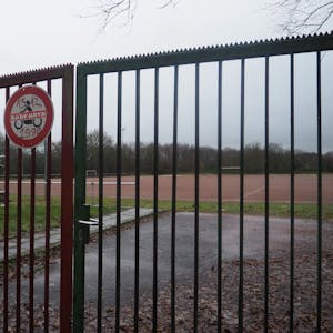 Auf dem Foto ist der Kierdorfer Sportplatz hinter einem verschlossenen Tor zu sehen.
