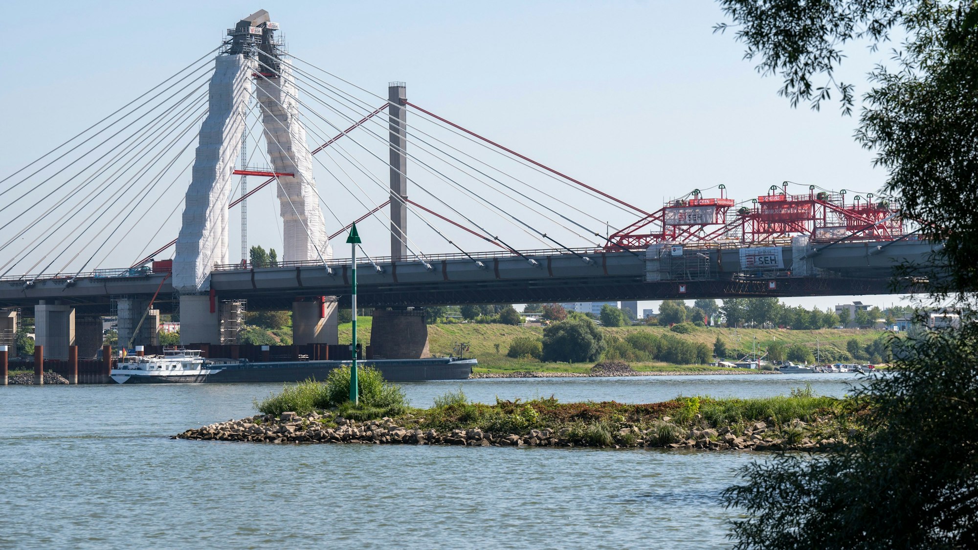 Die neue Leverkusener Brücke ist fast fertig. Das letzte Stahlbauteil ist eingebaut. Das Bauwerk soll voraussichtlich Anfang 2024 freigegeben werden. Blick auf die Brückenbaustelle vom Rheinufer aus.